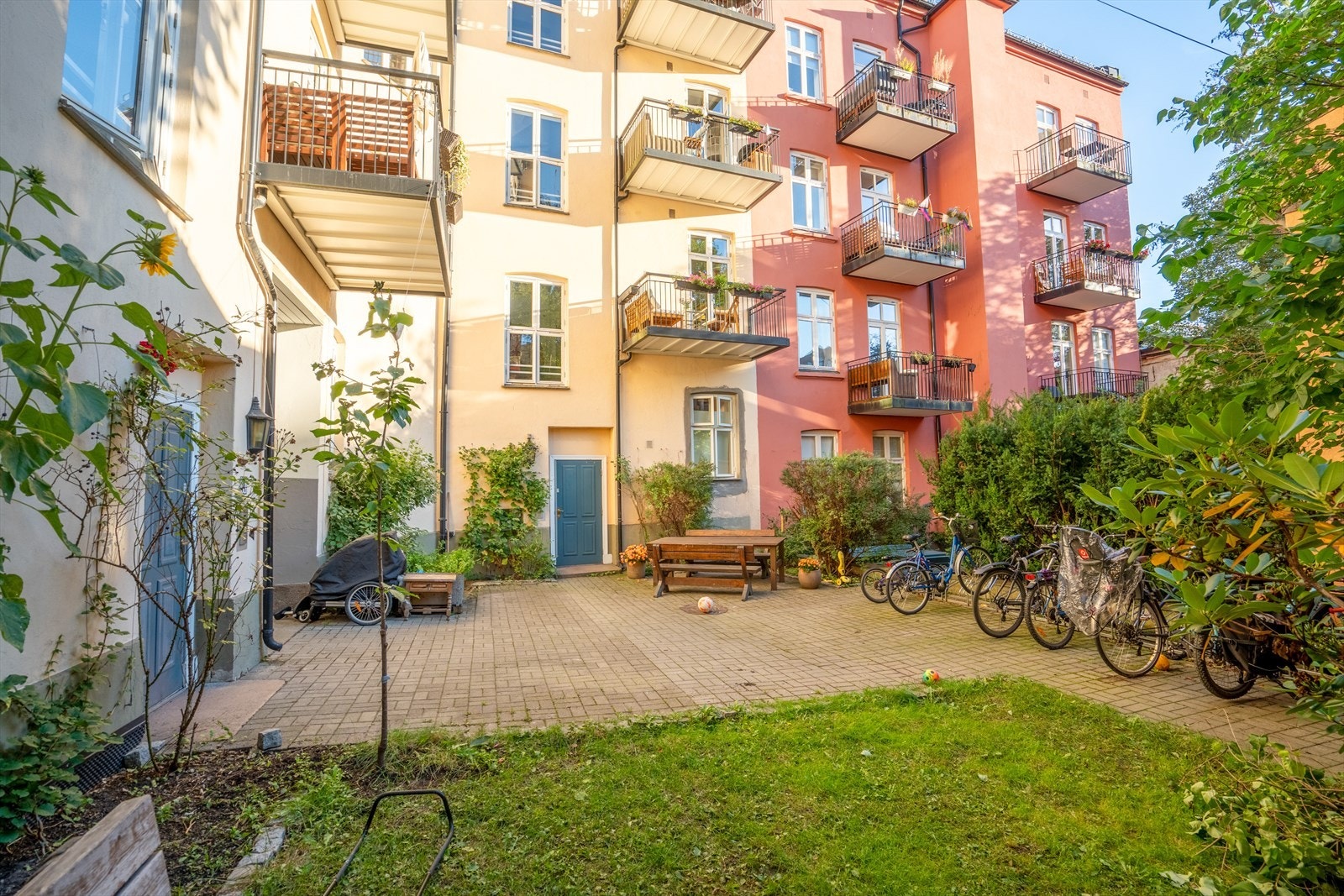 Bakgården er pent opparbeidet med plen, beplantning og brostein. Galleribilde