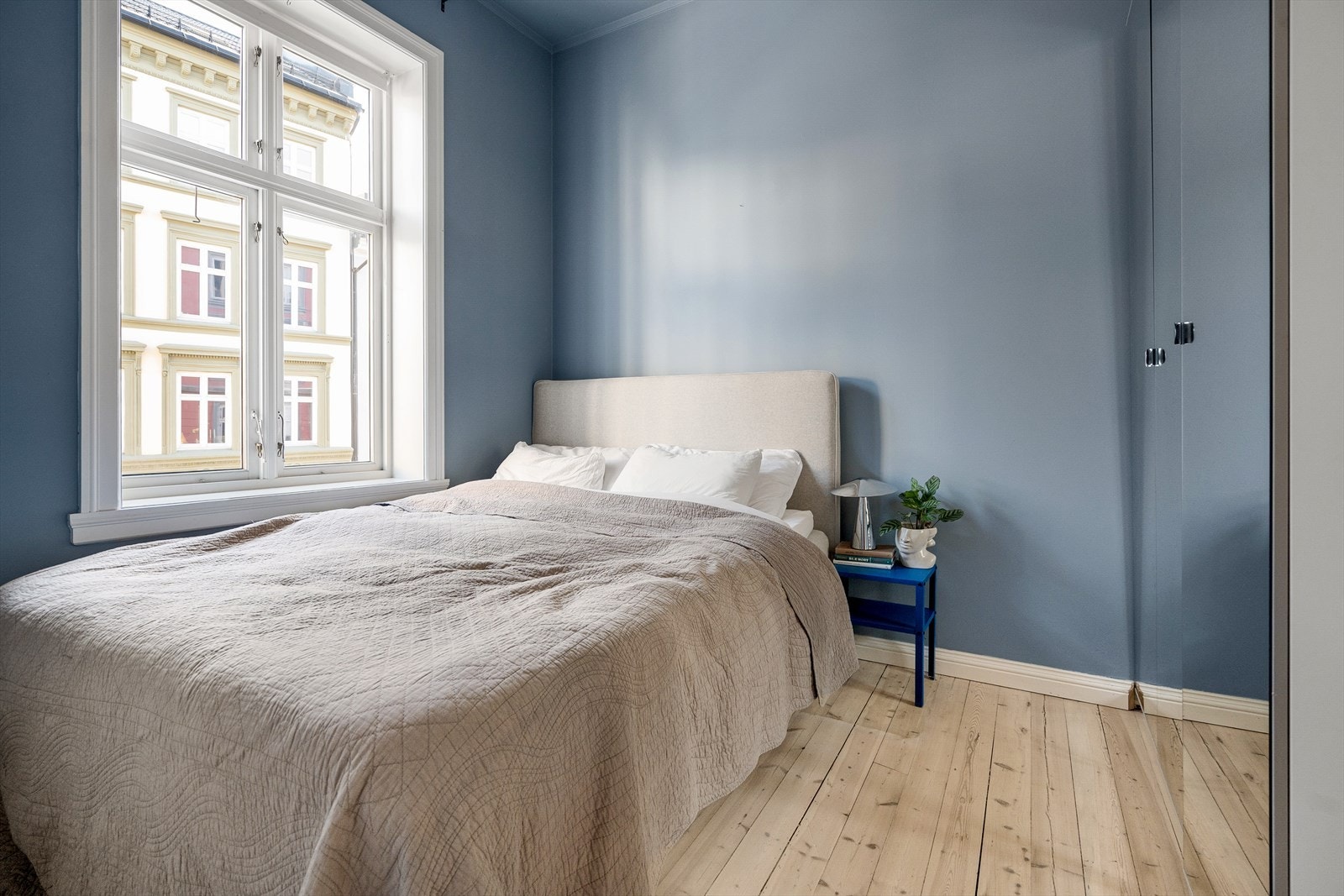 Rommet har stort vindu som sikrer godt med lys og luft. Soverommet er malt i en behagelig blåtone. Galleribilde