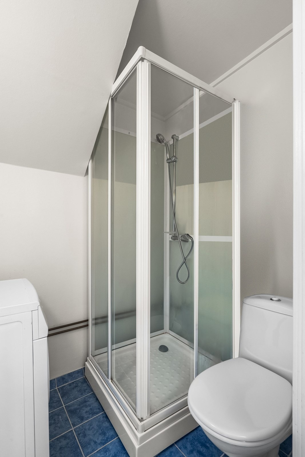 Bad med opplegg for vaskemaskin. Badet har dusj, toalett og servant. Galleribilde