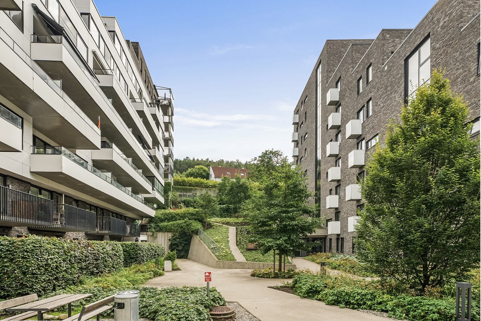 Pene fellesarealer opparbeider med variert beplantning, sittebenker og gangstier Galleribilde