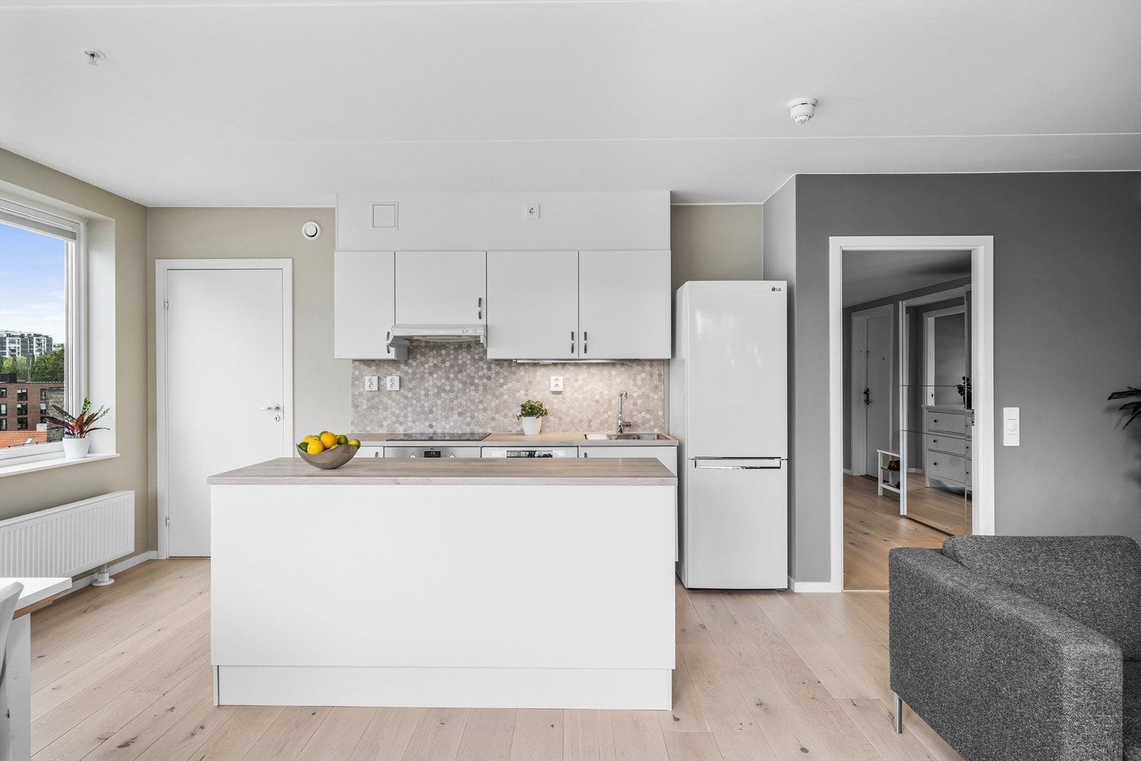 Aubo kjøkkeninnredning (2017) med glatte fronter - I 2021 ble det lagt mosaikkfliser på vegg over benkeskap og ny laminat benkeplate Galleribilde