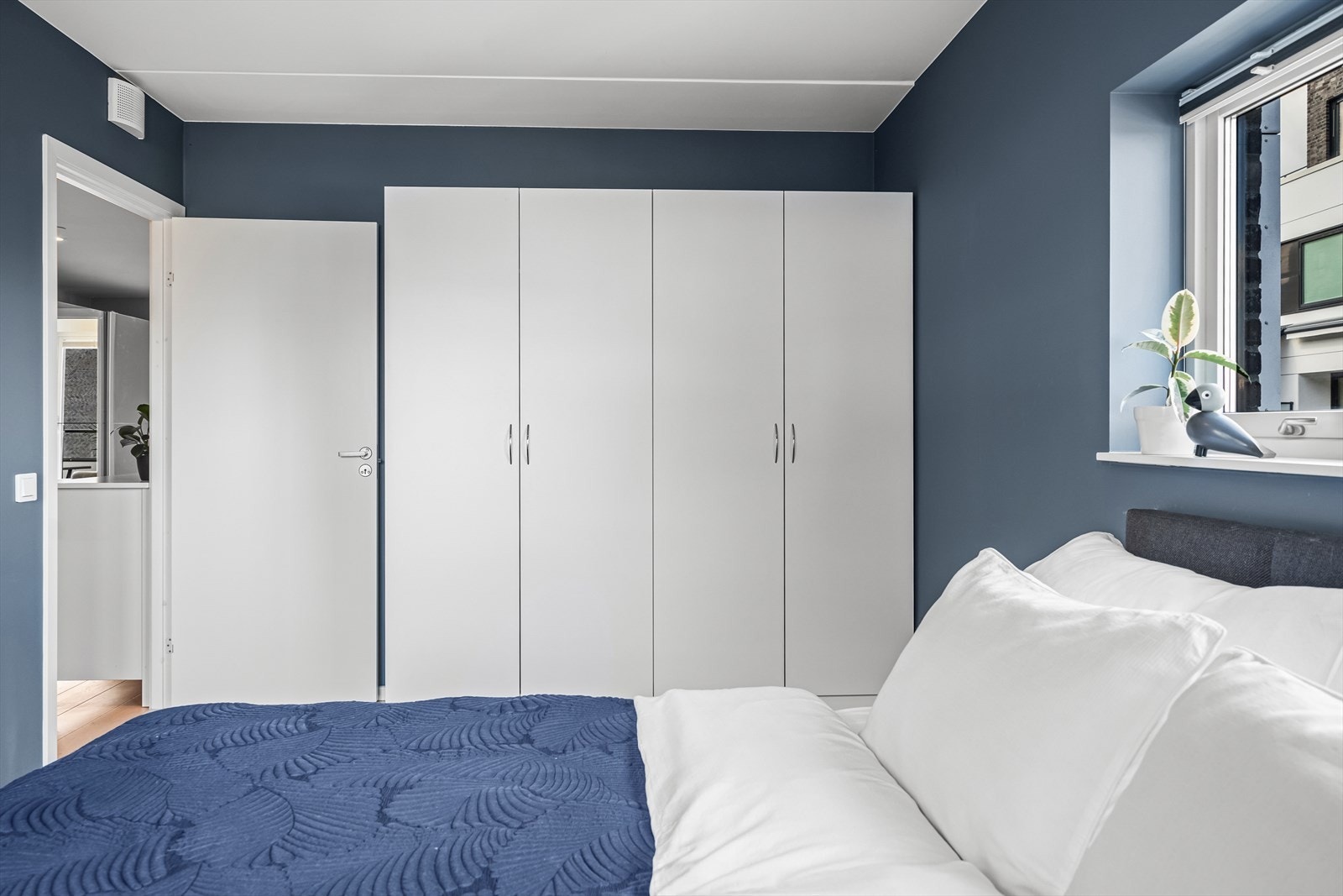 God plass til stor dobbelseng, tilhørende nattbord og oppbevaring i garderobeskap Galleribilde