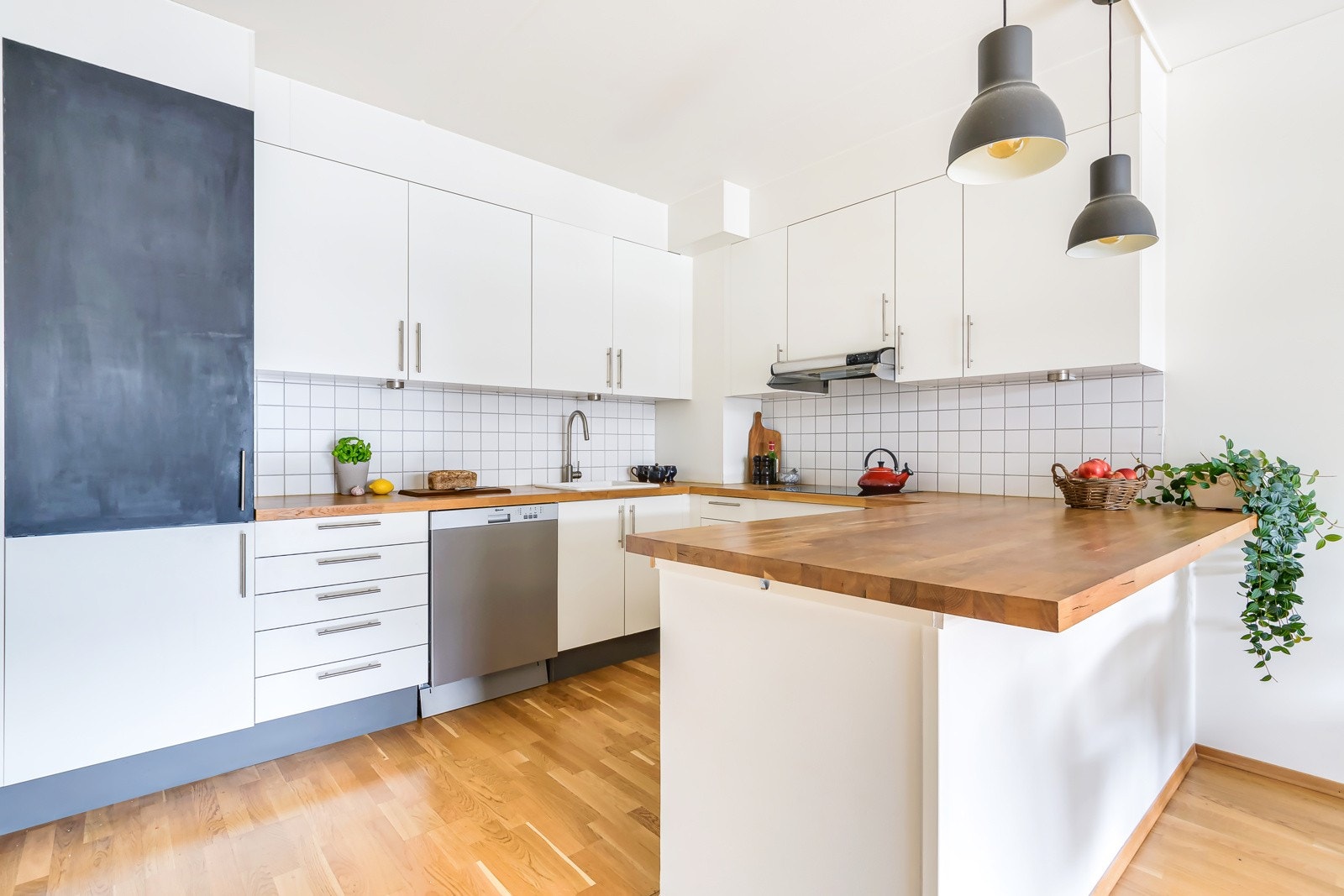 Kjøkkeninnredning med slette lakkerte fronter, og benkeplate i heltre. Galleribilde