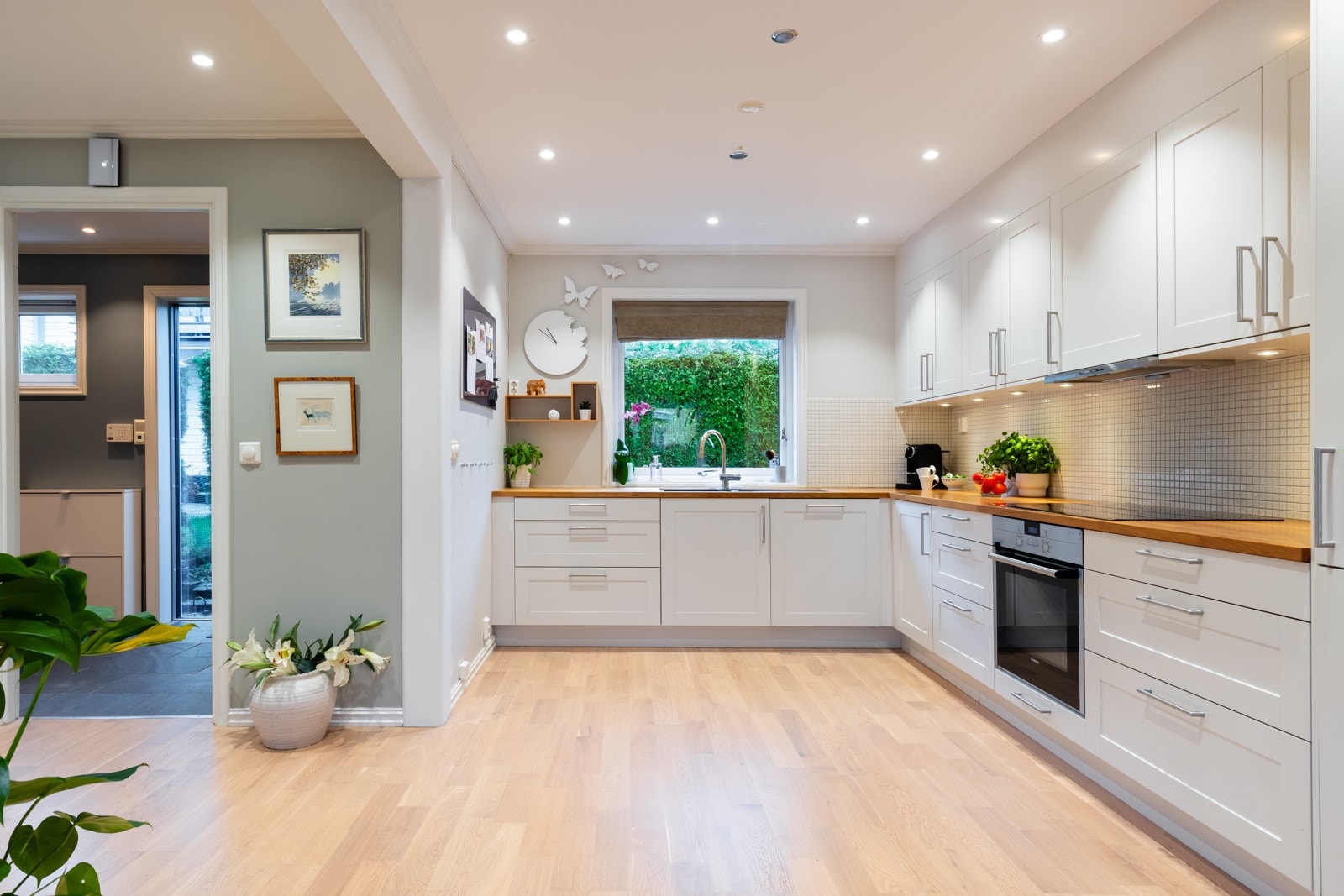 Romslig og pent Norema kjøkken fra 2015. De hvite kjøkkenfrontene og benkeplaten i heltre gir et tidløst og varmt preg. Galleribilde