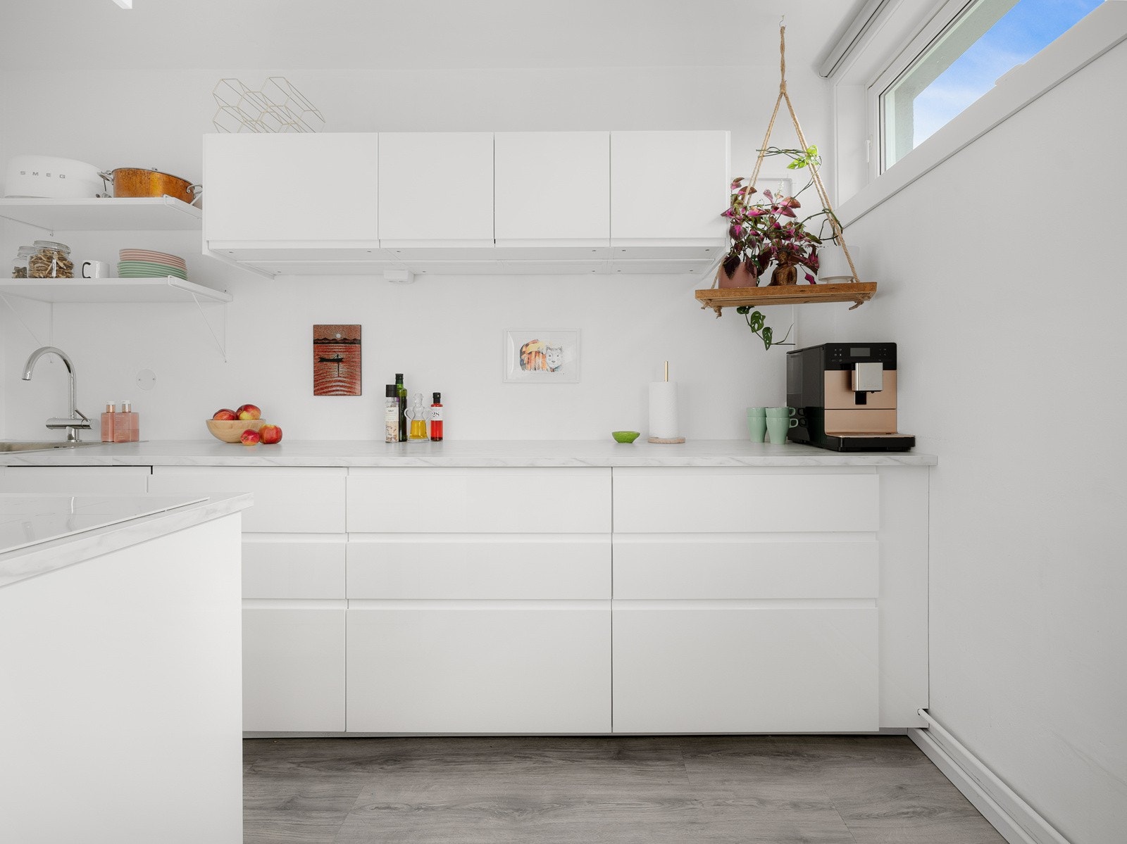 Dette moderne og stilrene kjøkkenet er en del av en åpen løsning, med lyse, glatte fronter fra IKEA i høyglans utførelse Galleribilde