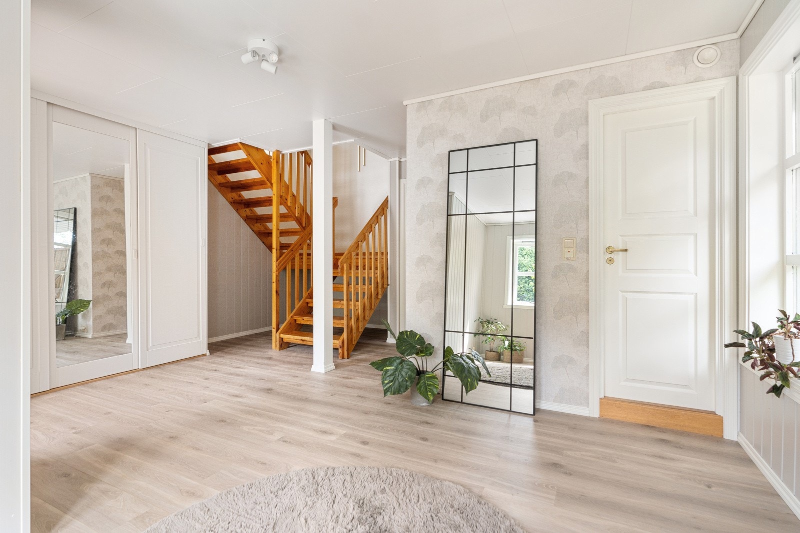Romslig gang på 23,5 m² med Pergo laminatgulv og malt smartpanel på veggene. Galleribilde