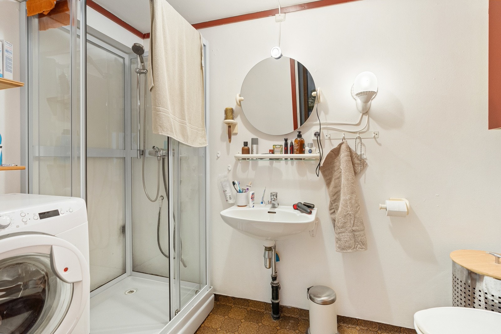 Badet er 4,5 m² og inneholder servant, speil, belysning, toalett, dusjkabinett og opplegg for vaskemaskin. Vaskemaskin medfølger handelen. Galleribilde