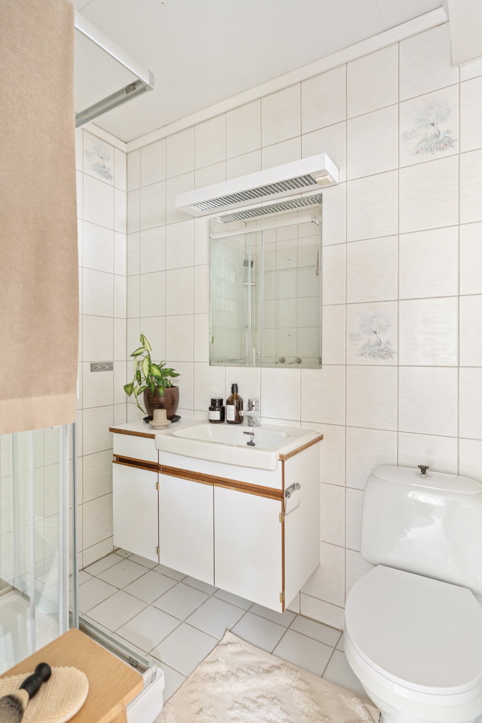 Badet inneholder servant med møblement/speil, belysning, toalett og dusjkabinett. Galleribilde