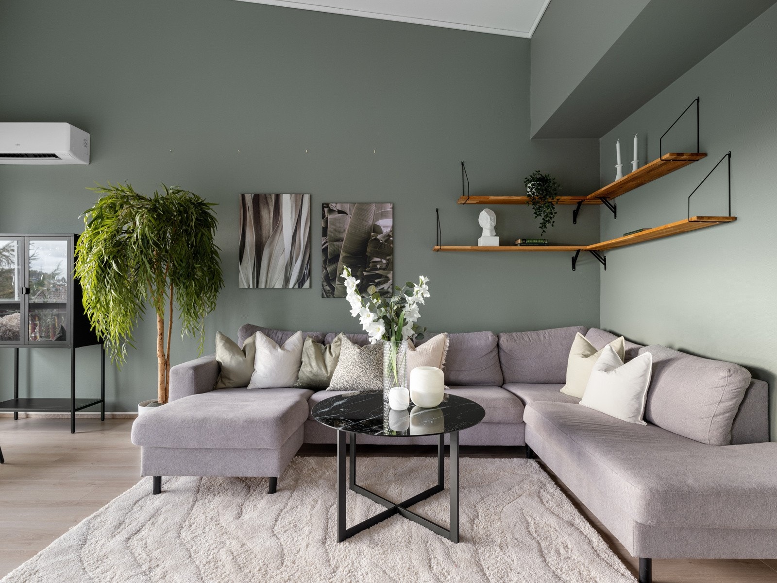 Veggene er malt i en stilren grønnfarge, som gir rommet et moderne preg. Galleribilde