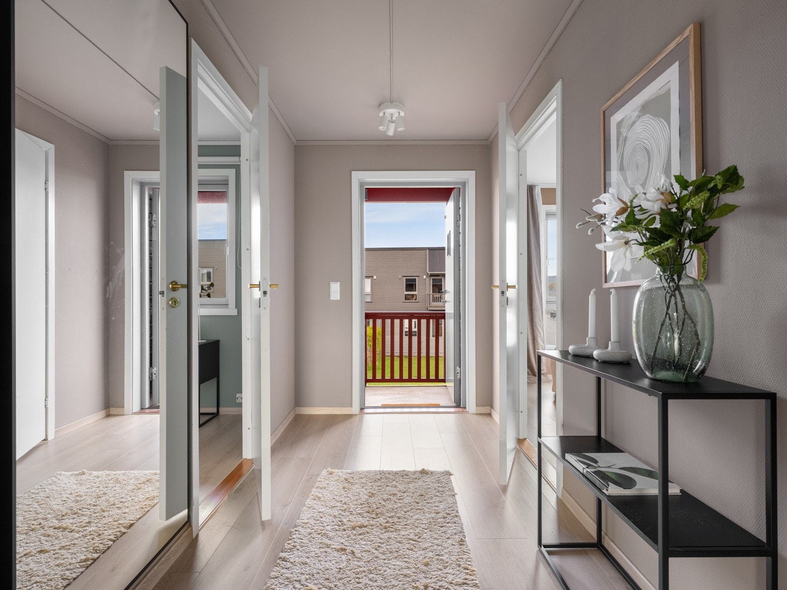 Når man åpner døren, kommer man inn i en entrè som tilbyr flere oppbevaringsmuligheter for yttertøy og sko. Gulvet har fått nytt laminat som ble lagt i 2024. Vegger og tak er malt i samme farge, noe som gir rommet et lyst og moderne preg. Galleribilde