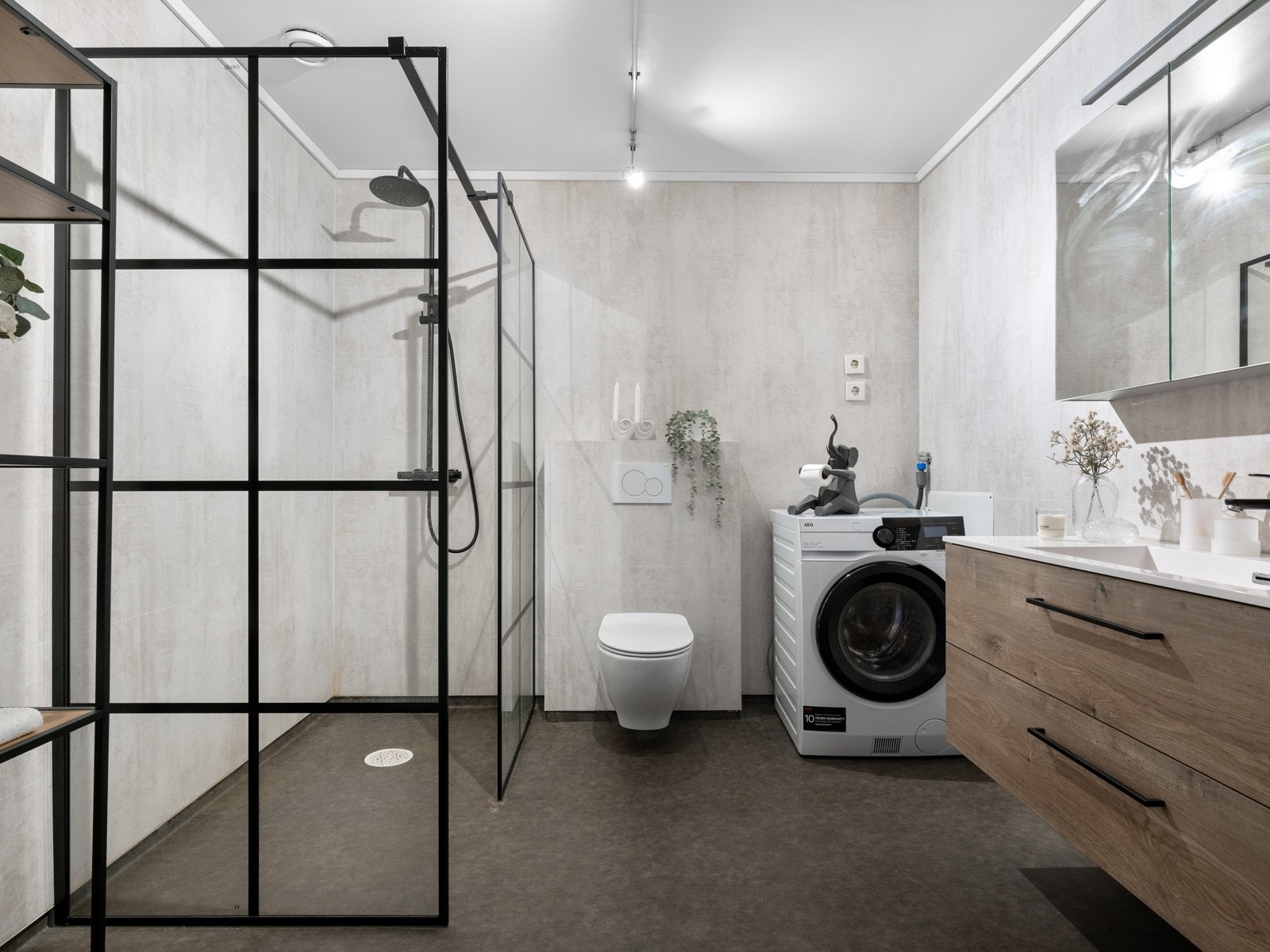 Badet ble oppusset i 2020, har mørkegrå gulvbelegg med varmekabler og lyse baderomsplater på veggene. Innredningen består av et vegghengt baderomsmøbel med to romslige skuffer og en heldekkende servant, samt et stort speilskap med belysning over. Galleribilde