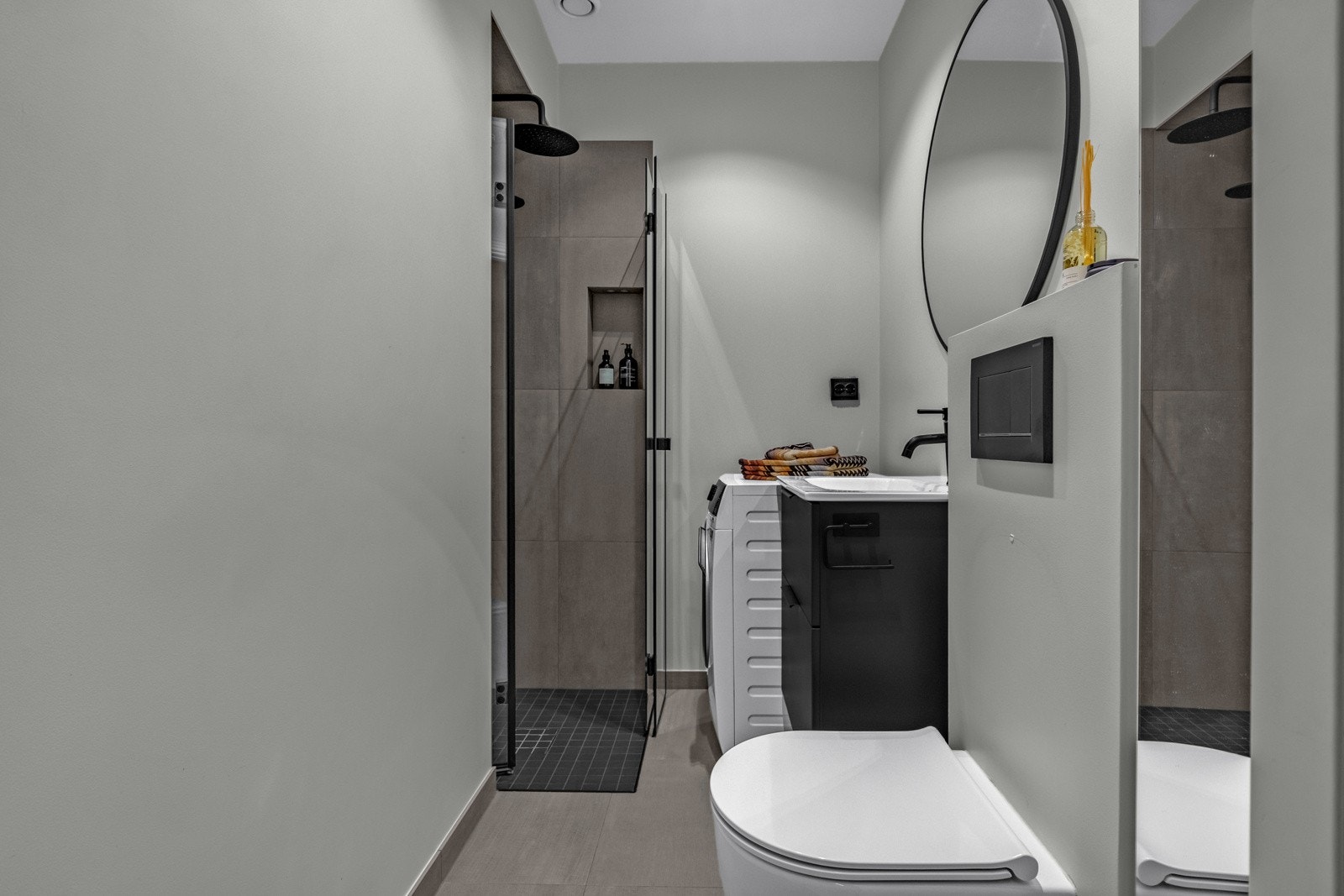 Moderne baderom med varme i gulvet og opplegg for vaskemaskin. Galleribilde