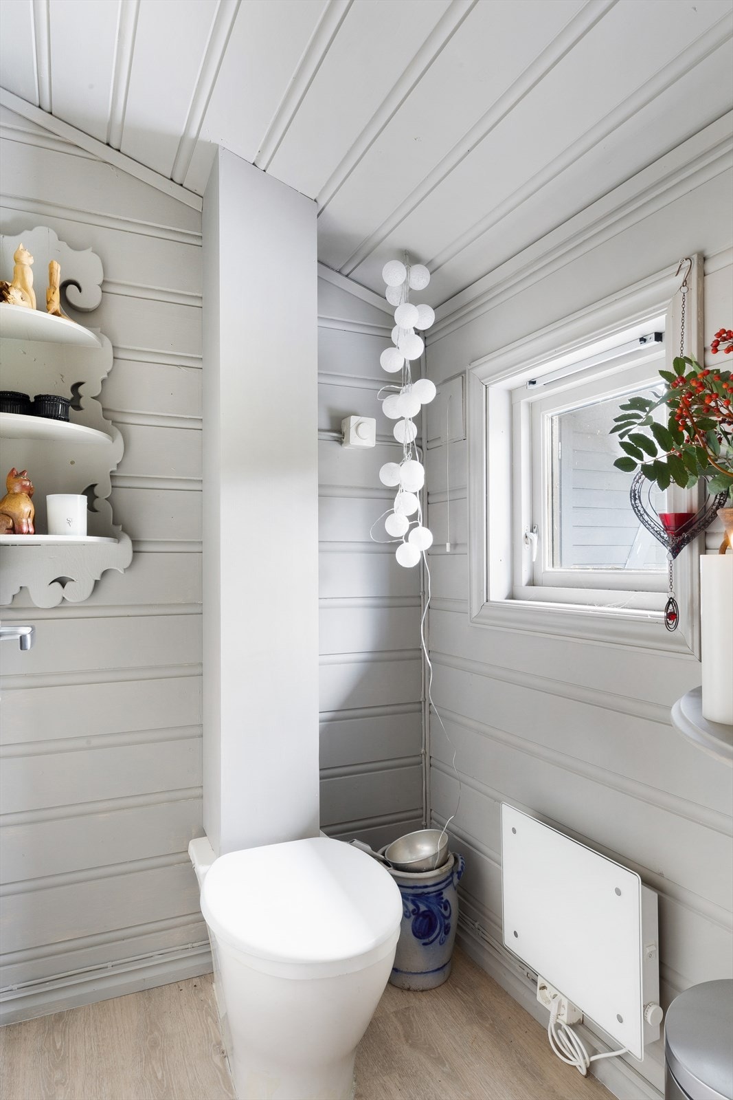 Separat toalettrom med biotoalett. Her er det laminat på gulv og malt panel på vegger. Galleribilde