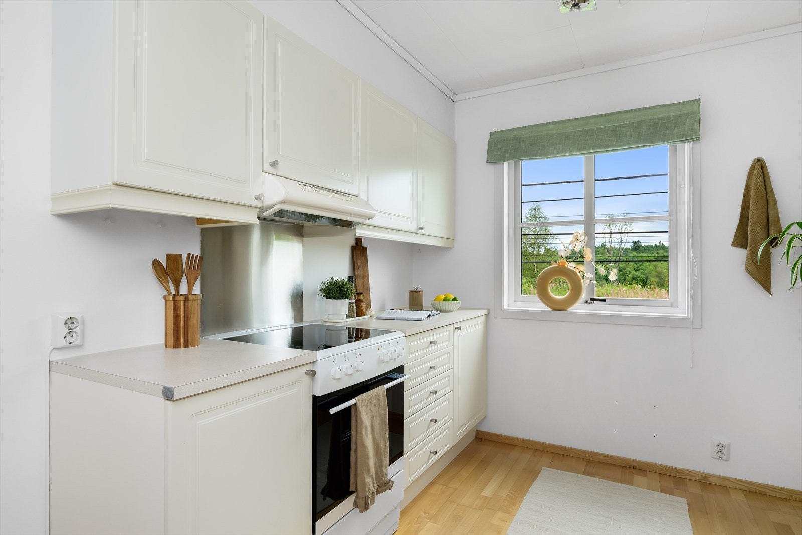 Kjøkkenet er utstyrt med kjøkkeninnredning med profilerte fronter, laminat benkeplate, stål oppvaskkum og ventilator Galleribilde