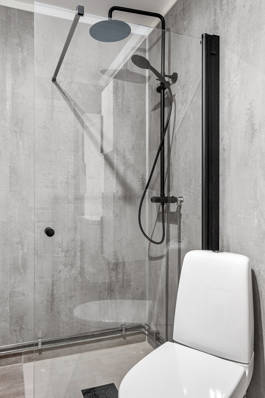 Badet er innredet med servant på innredning, toalett og dusjhjørne med glassdør. Galleribilde