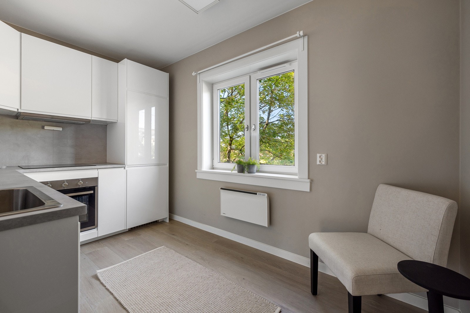 Kjøkken har godt med skap og benkeplass samt flis over benkeplaten, lyse flater som gir en tidløs stil. Galleribilde