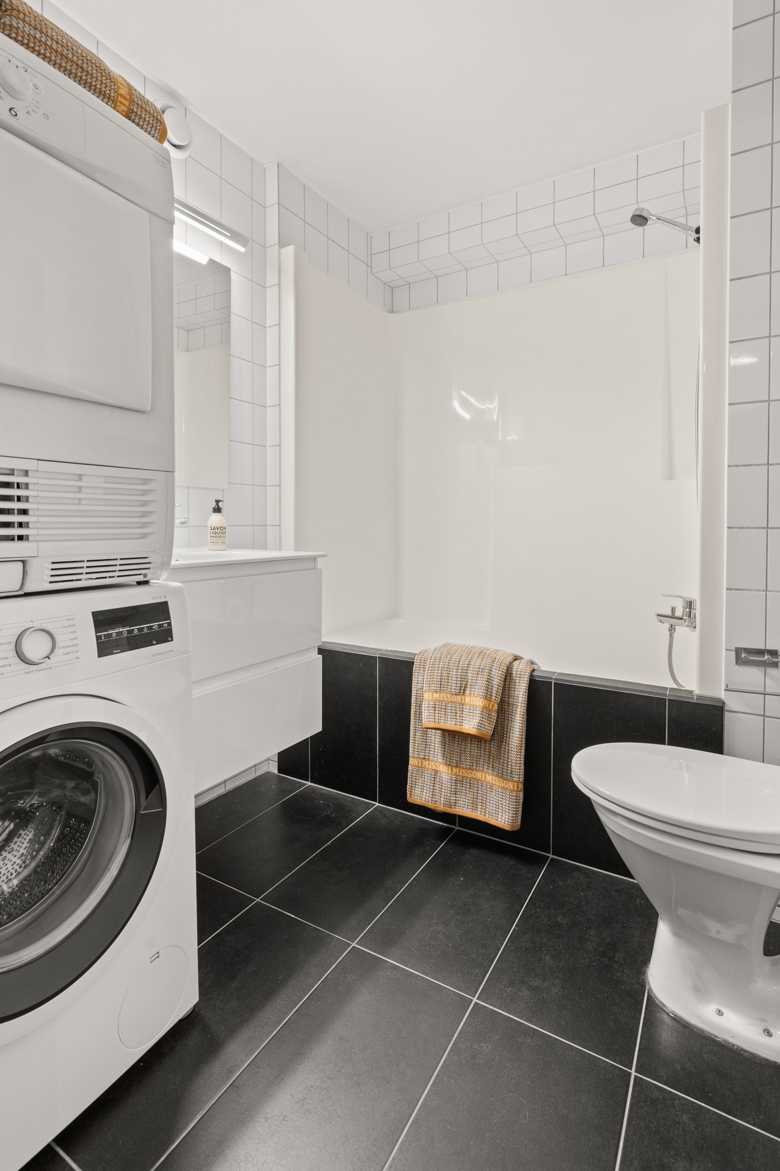 Badet er innredet med servantskap, servant, speil, badekar med dusj og toalett. Galleribilde
