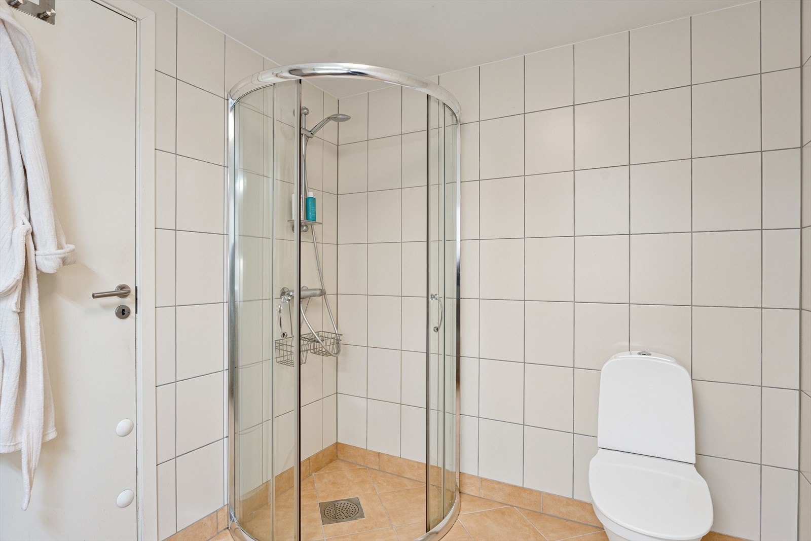 Badet er har gulvmontert toalett og romslig dusjhjørne med glassdører Galleribilde