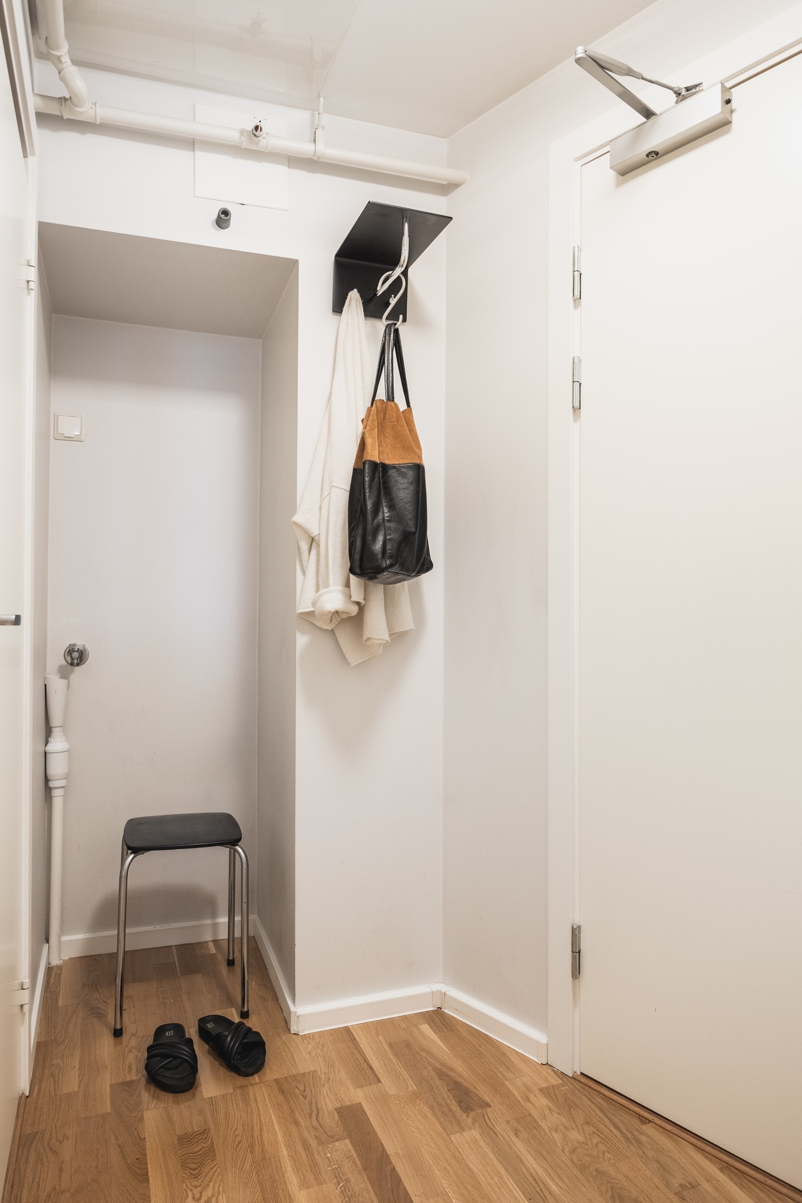 Lys entré med plass til oppheng av yttertøy og oppbevaring av sko. Entréen har opplegg for vaskemaskin. Galleribilde