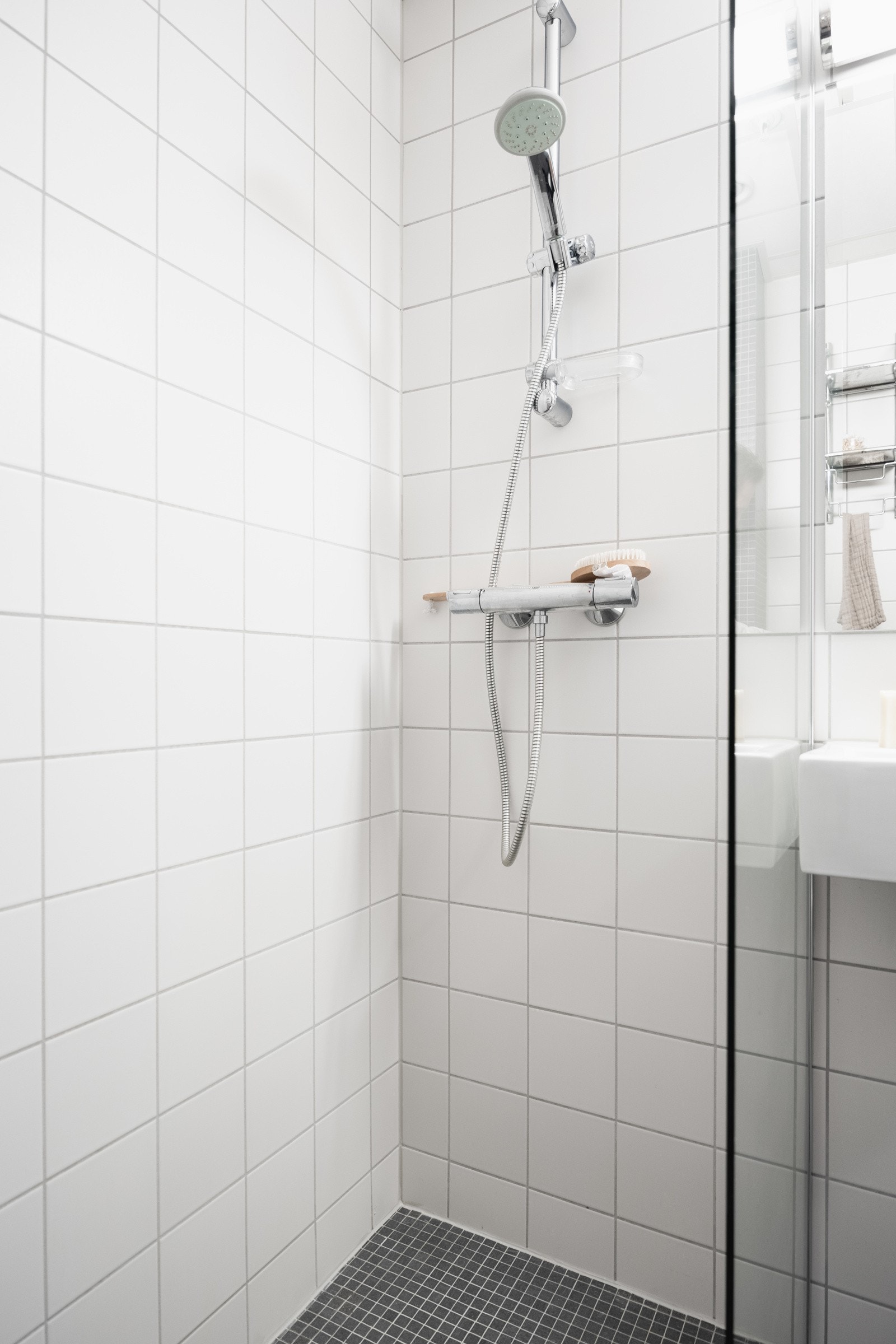 Dusj på gulv med glassvegg. Avtrekksventil plassert i himling. Galleribilde