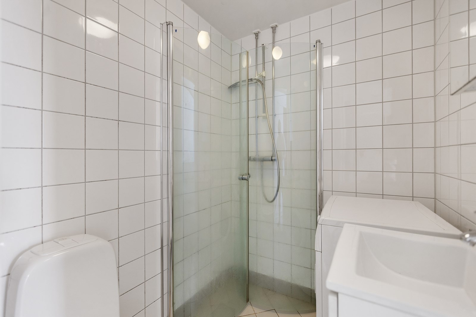 Lyst, flislagt bad som er oppusset i regi av borettslaget i 2010. Baderomsinnredning med servant på underskap og speilskap over. Galleribilde