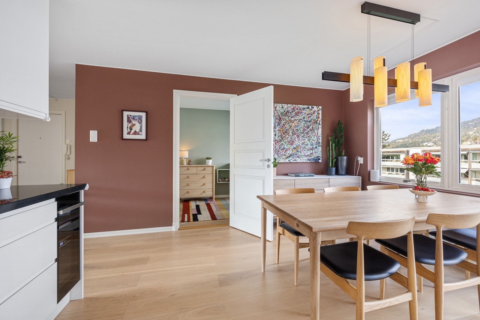 Kjøkkenet har integrert platetopp, stekeovn, oppvaskmaskin, kjøl/frys og vinkjøler, samt ventilator med sort glassfront. Galleribilde