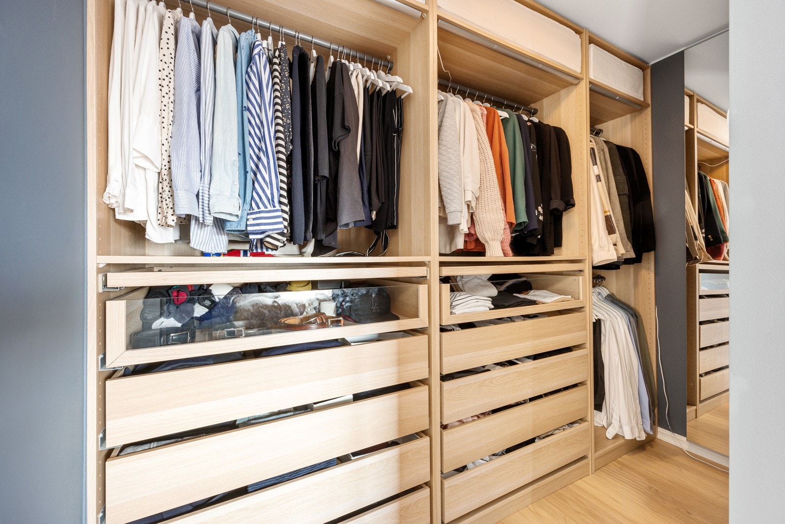 Her er det speil og takhøye skap med skuffer, hyller og heng, som gjør det enkelt å holde orden i garderoben. Galleribilde