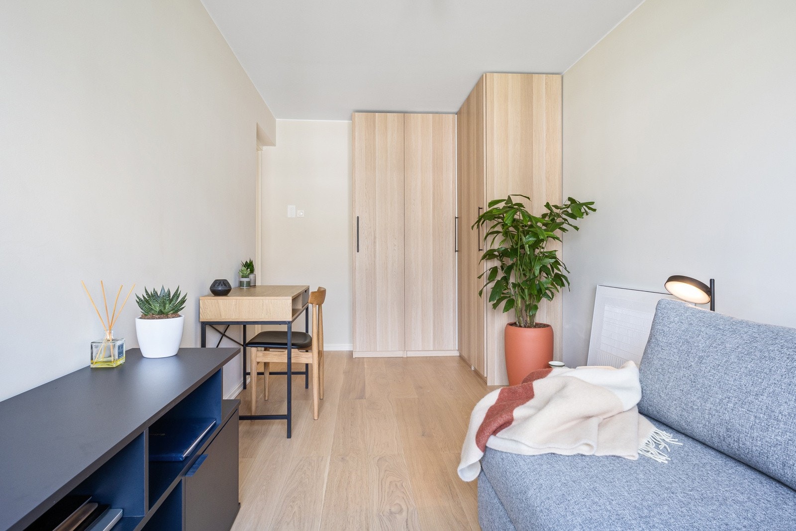 Det ene rommet har takhøye garderobeskap plassert i en smart hjørneløsning. Galleribilde