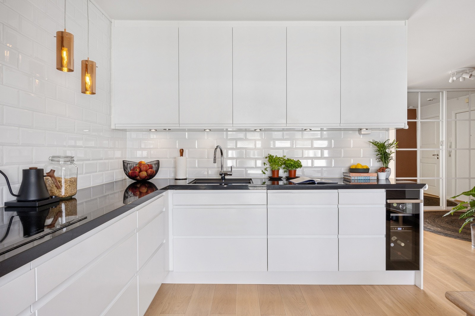 Det hele er stilrent utført og påkostet med benkeplate i steinkompositt og alt av integrerte hvitevarer, inkl. vinskap. Galleribilde