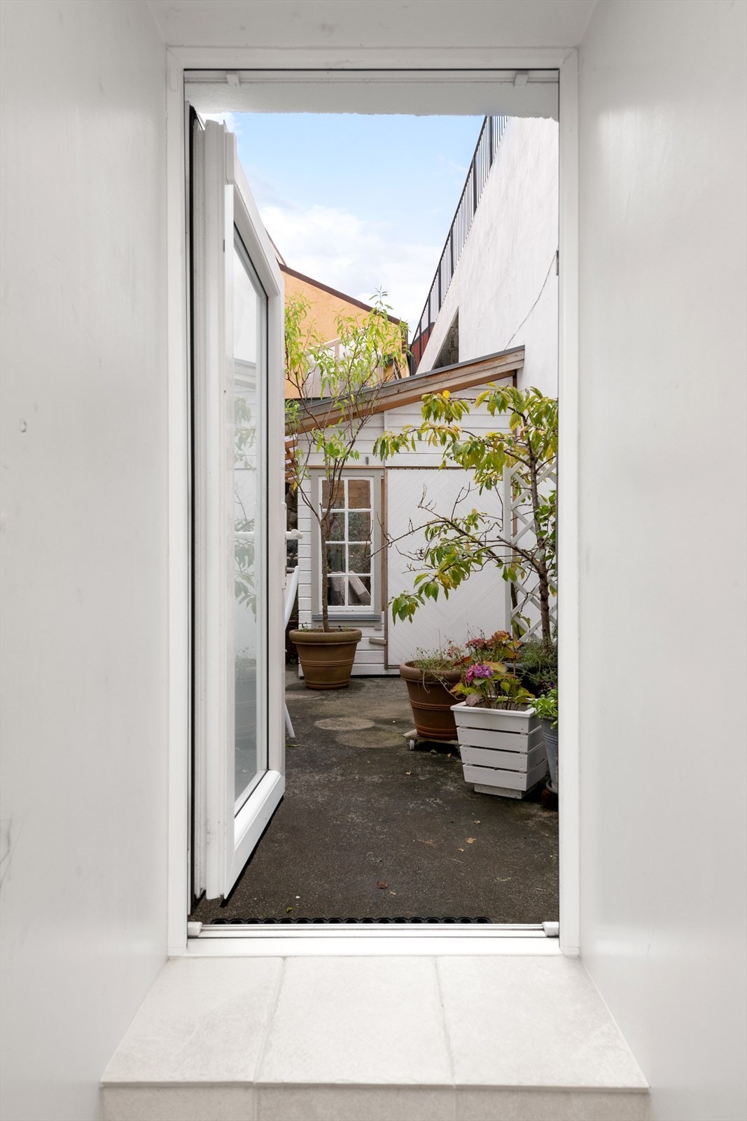 Det er utgang fra bad til uteplass og terrasse i bakgård som disponeres av denne seksjonen Galleribilde