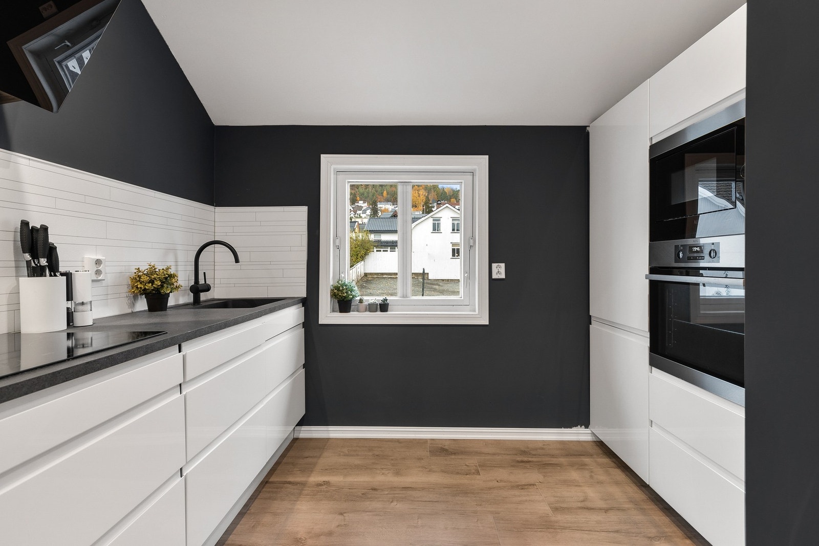 Stilren kjøkkeninnredning fra 2021 med glatte fronter og benkeplate av laminat med nedfelt oppvaskkum med ett-greps kjøkkenarmatur Galleribilde