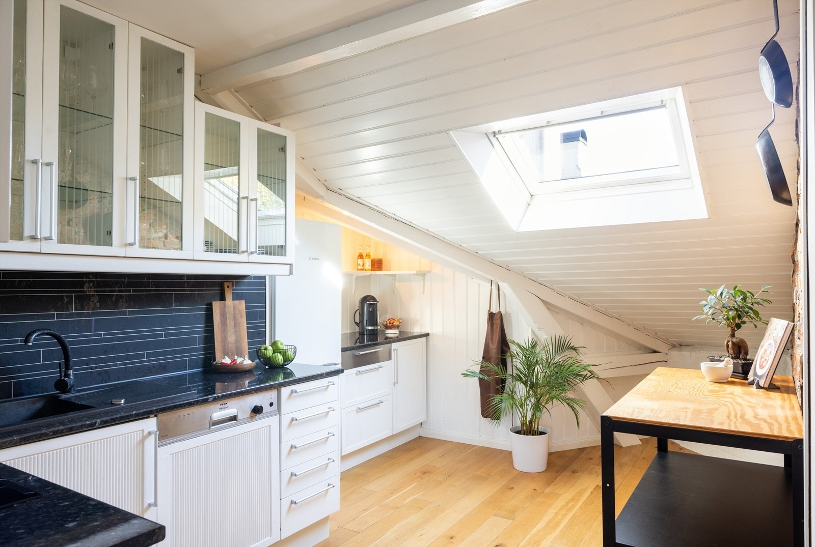 Videre er kjøkkenet utstyrt med keramisk platetopp, stekeovn, oppvaskmaskin og kullfilterventilator over kokeplass. Galleribilde