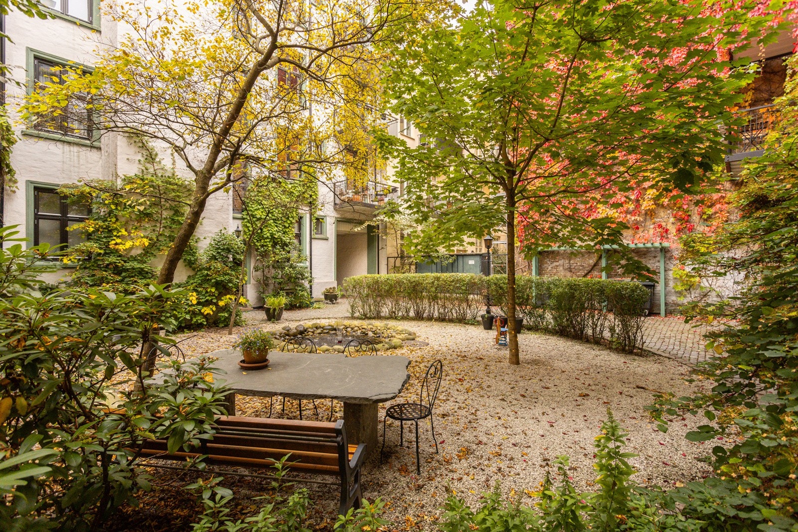 Gårdsrommet har sittegruppe, fontene og frodig peplantning. Galleribilde