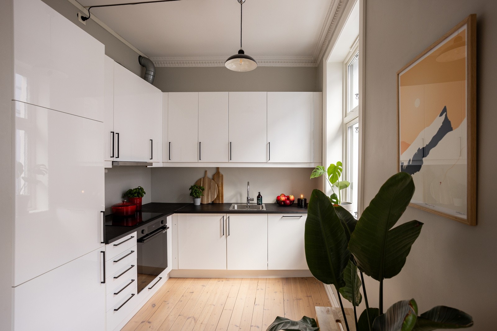 Den åpne løsningen mellom stuen og kjøkkenet er både sosial og praktisk. Galleribilde