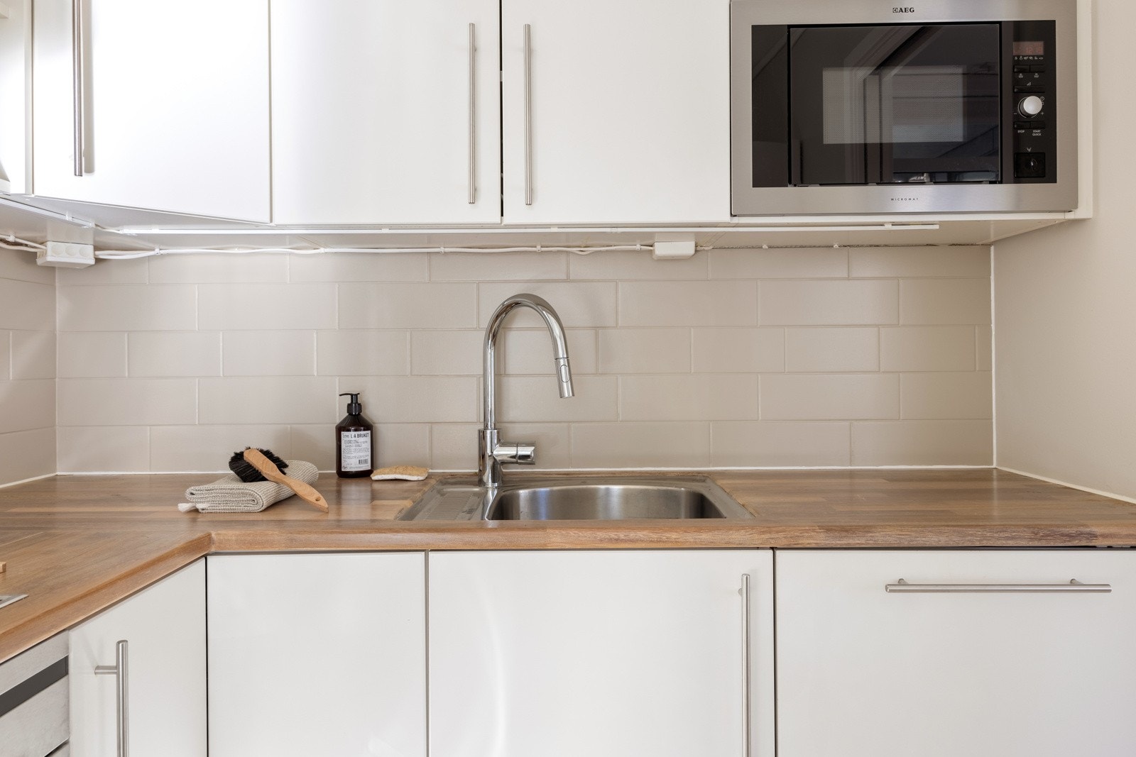 Fine materialsammensetninger også her. Under overskapene er det montert LED-lys (2024) og blandebatteriet ble skiftet i 2021. Galleribilde