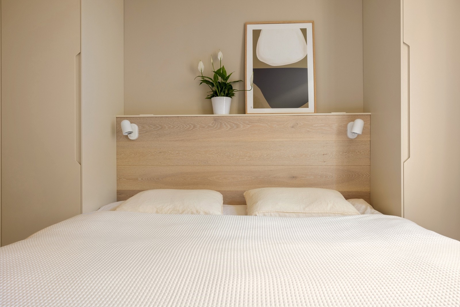 Plassbygget sengegavl med nattlamper og stikkontakter. Her kan man få hotellfølelsen hjemme. Galleribilde