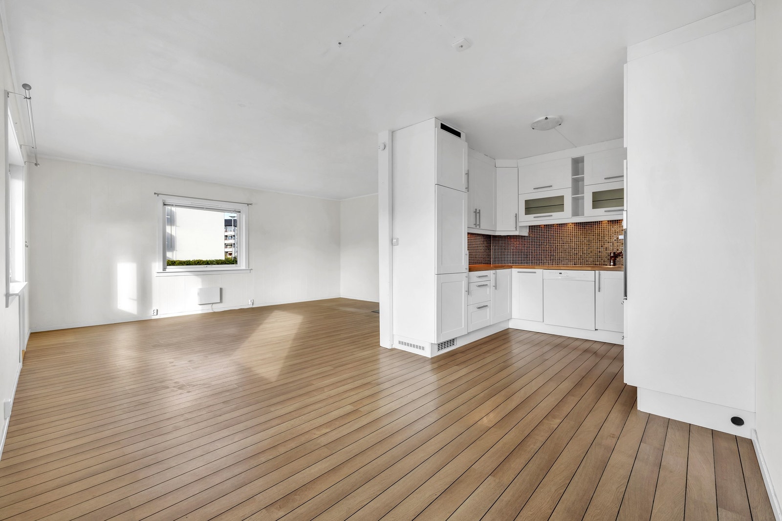 Delvis åpen kjøkken-stueløsning, her er det god plass til både sofagruppe og spisegruppe Galleribilde