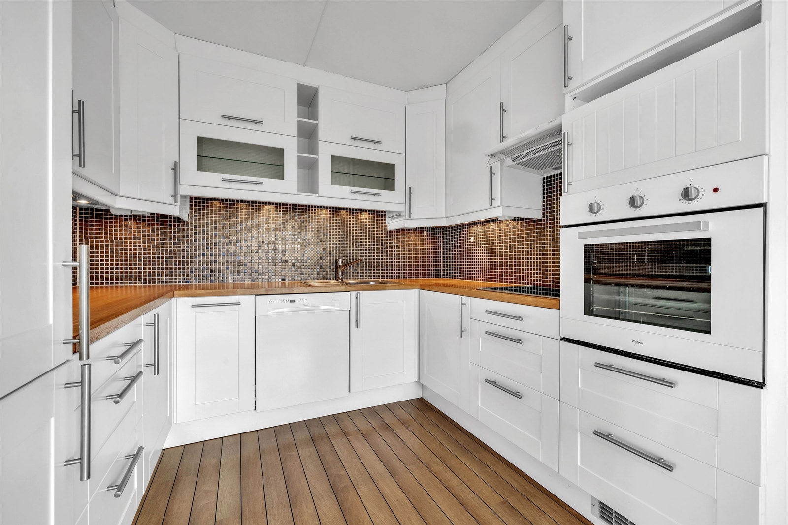 Kjøkken med integrerte hvitevarer som ovn, vaskemaskin og kjøleskap/fryser Galleribilde