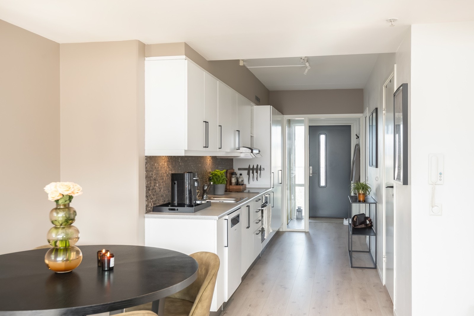Kjøkkenet ligger i en delvis åpen løsning med stuen. Det består av Folierte skrog, lakkerte fronter og laminert benkeplate. Flis på vegg over benkeplate. Galleribilde