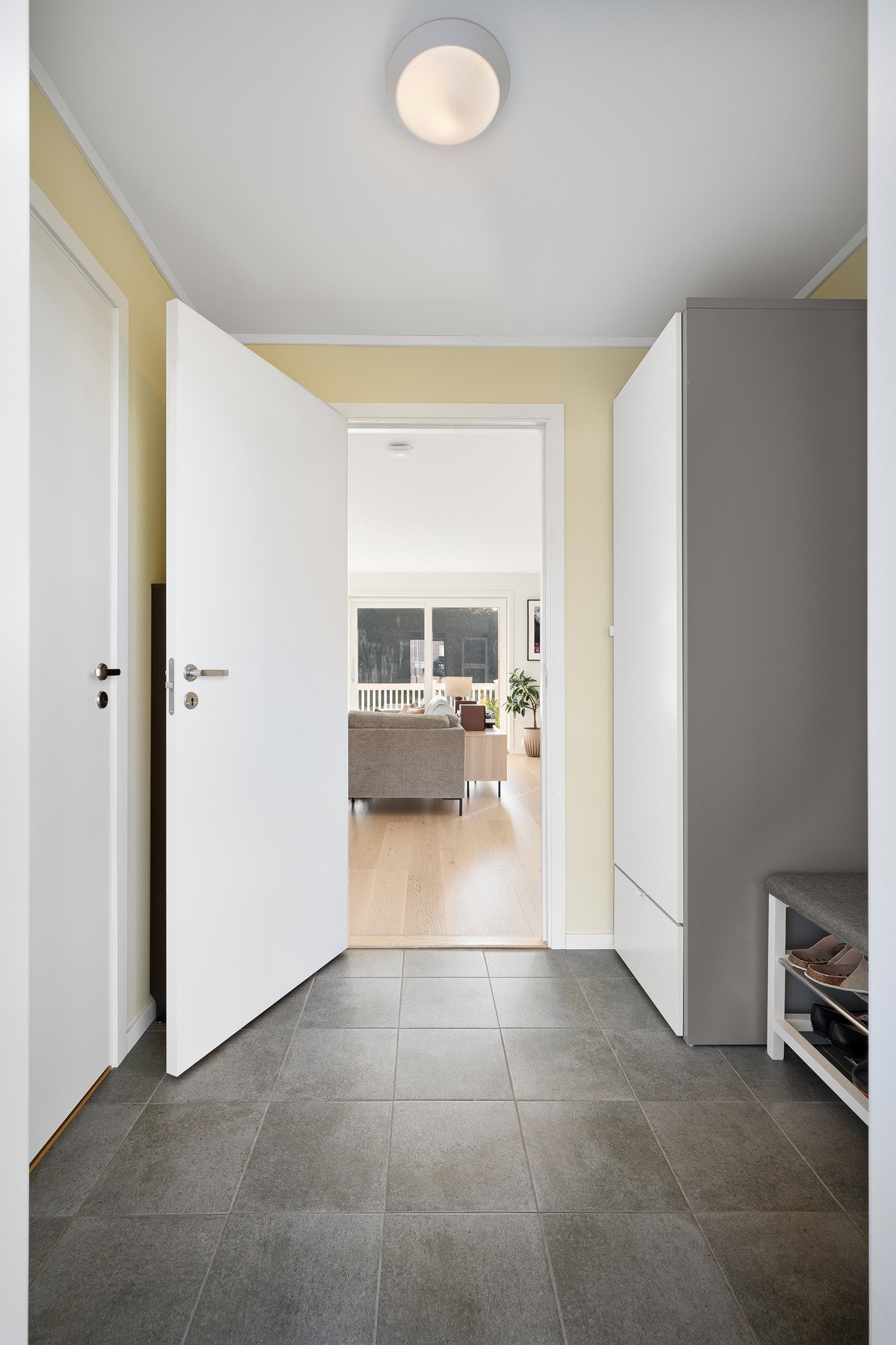 Romslig entré med flislagt gulv med varme Galleribilde