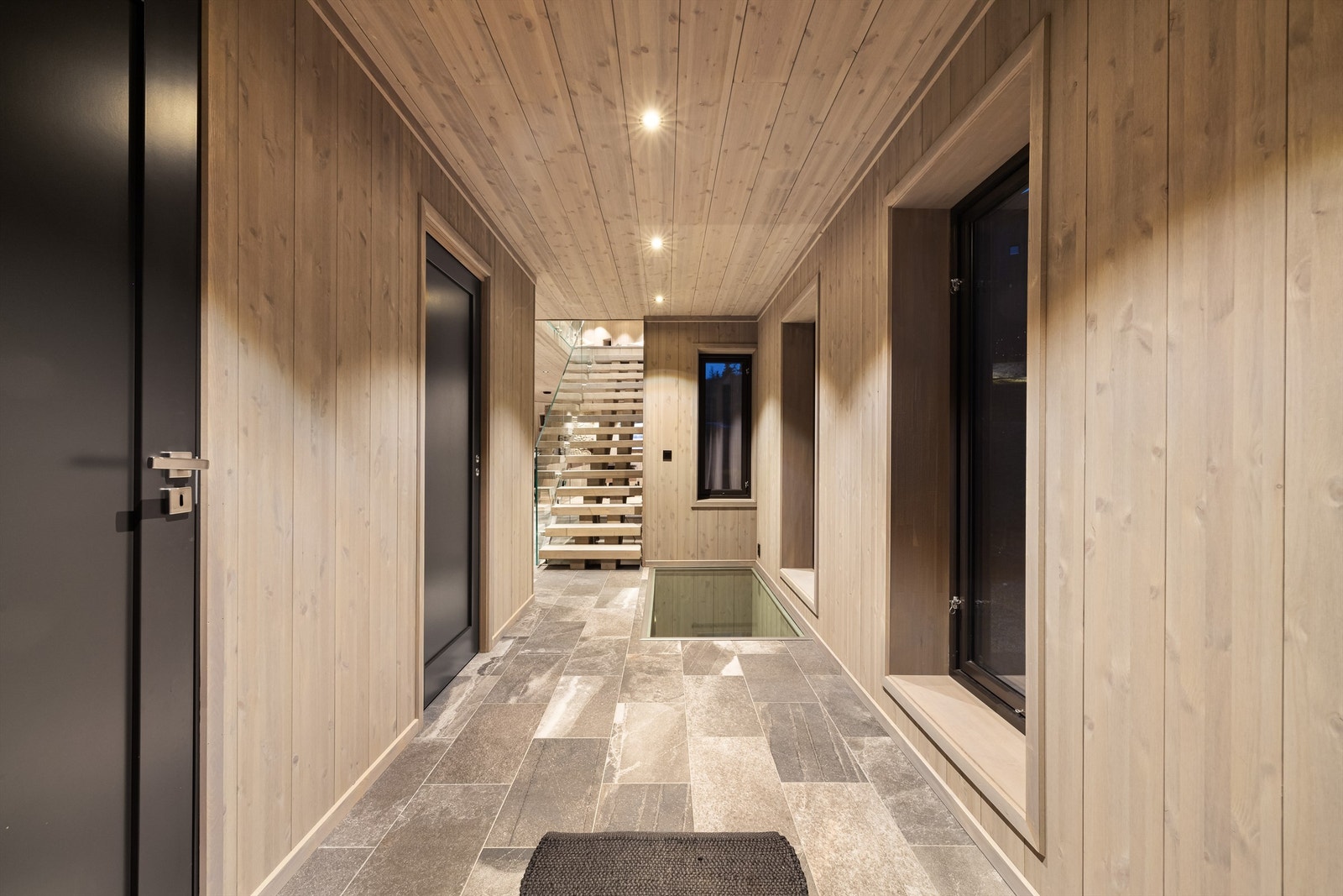 Nedfelt glassparti i hyttas hall. Galleribilde