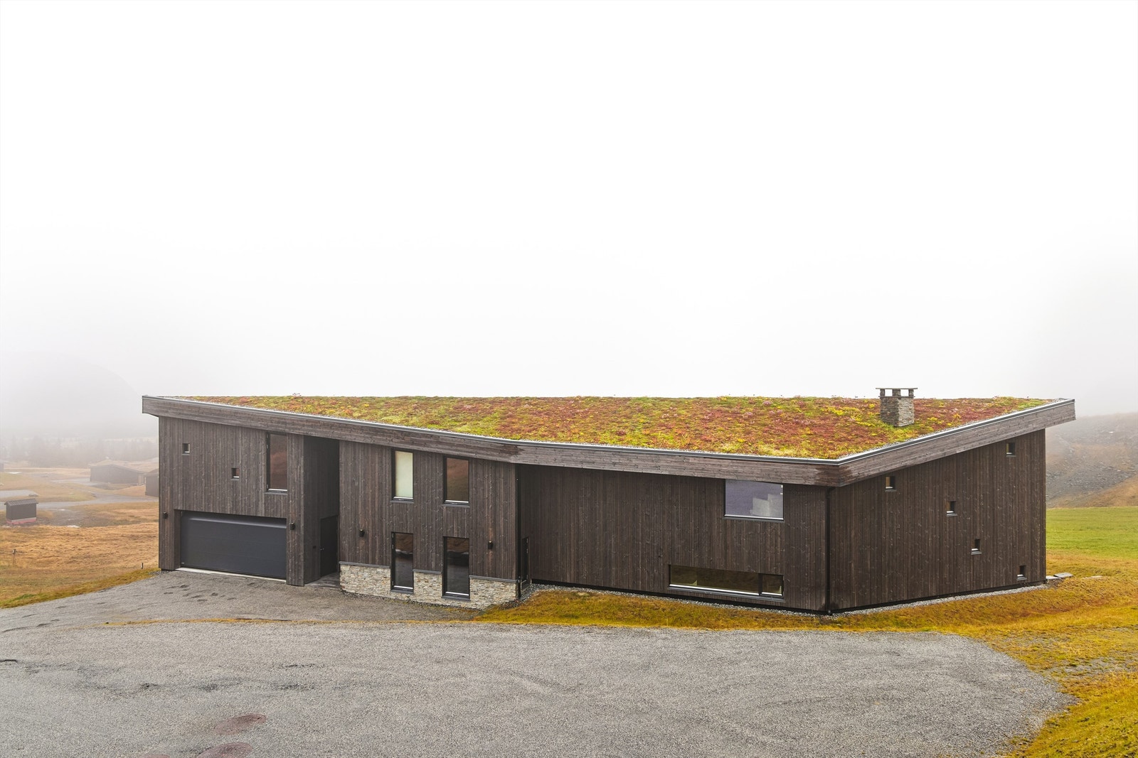 Stor dobbelgarasje med uinnredet loftsetasje. Etasjen er det både tilgang til fra garasjen og fra en bro mellom hytte og garasje. Galleribilde