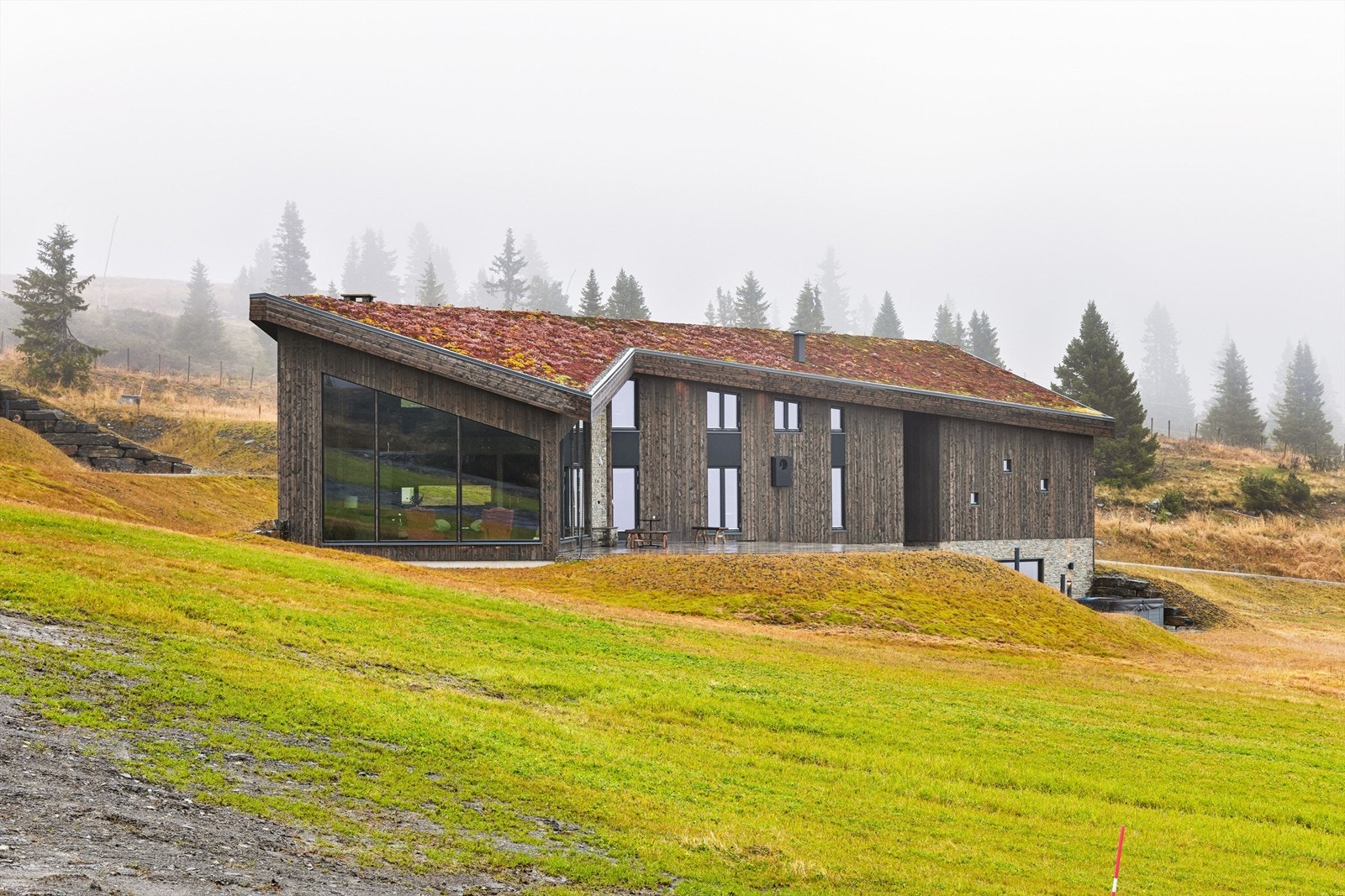 Hytta er pent integrert i fjellterrenget med yttertak tekket med sedumgress. Galleribilde