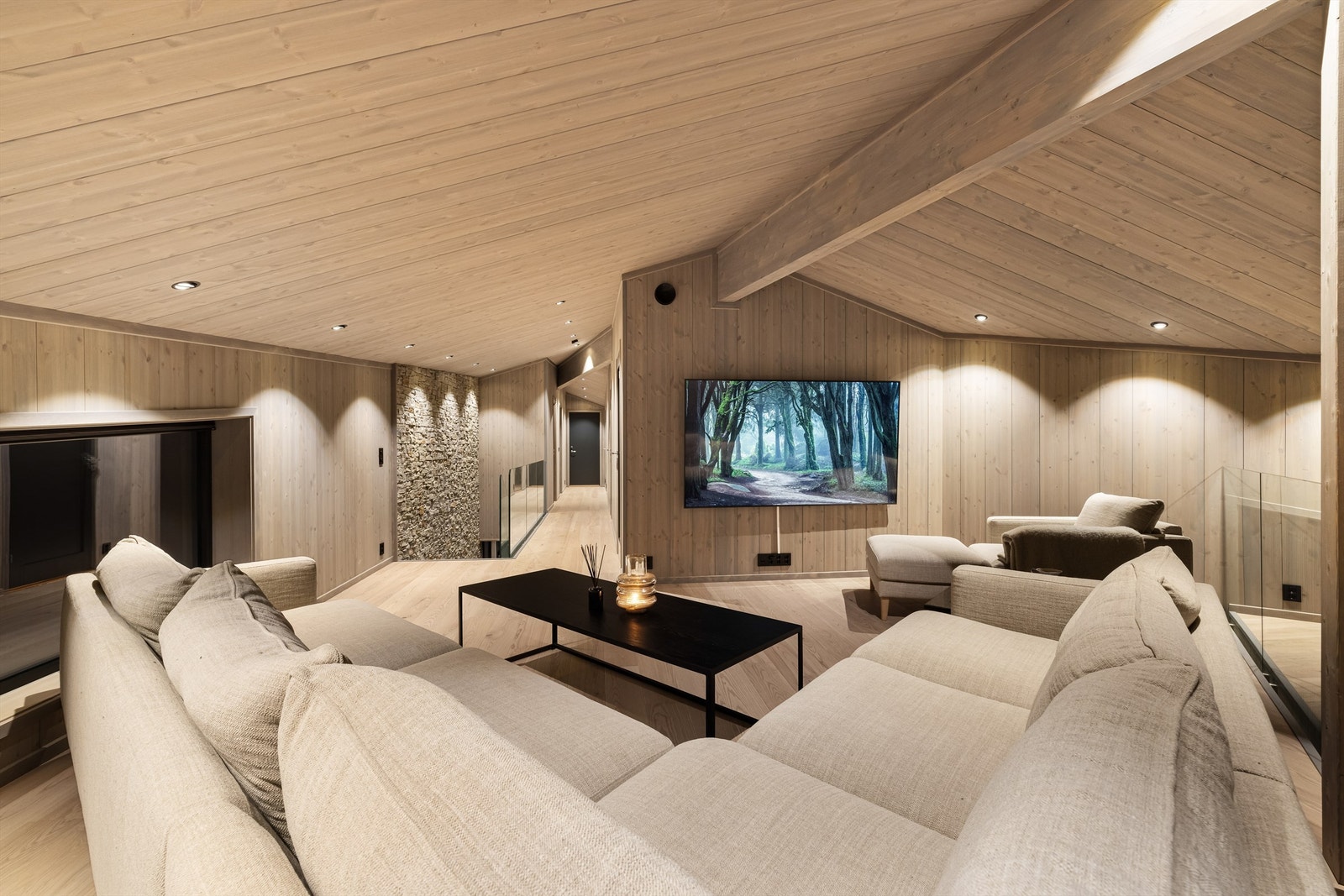 Fin og romslig loftstue med glassrekkverk mot stuen på nedsiden. Galleribilde