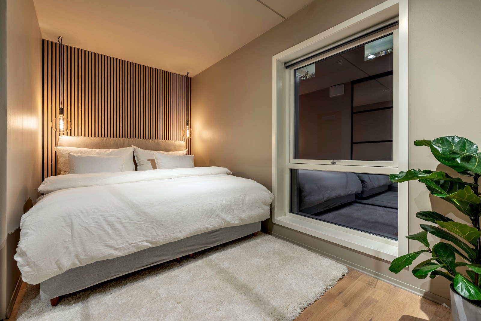 Romslig soverom med lys 3-stavs parkettgulv og lysmalte vegger. Galleribilde