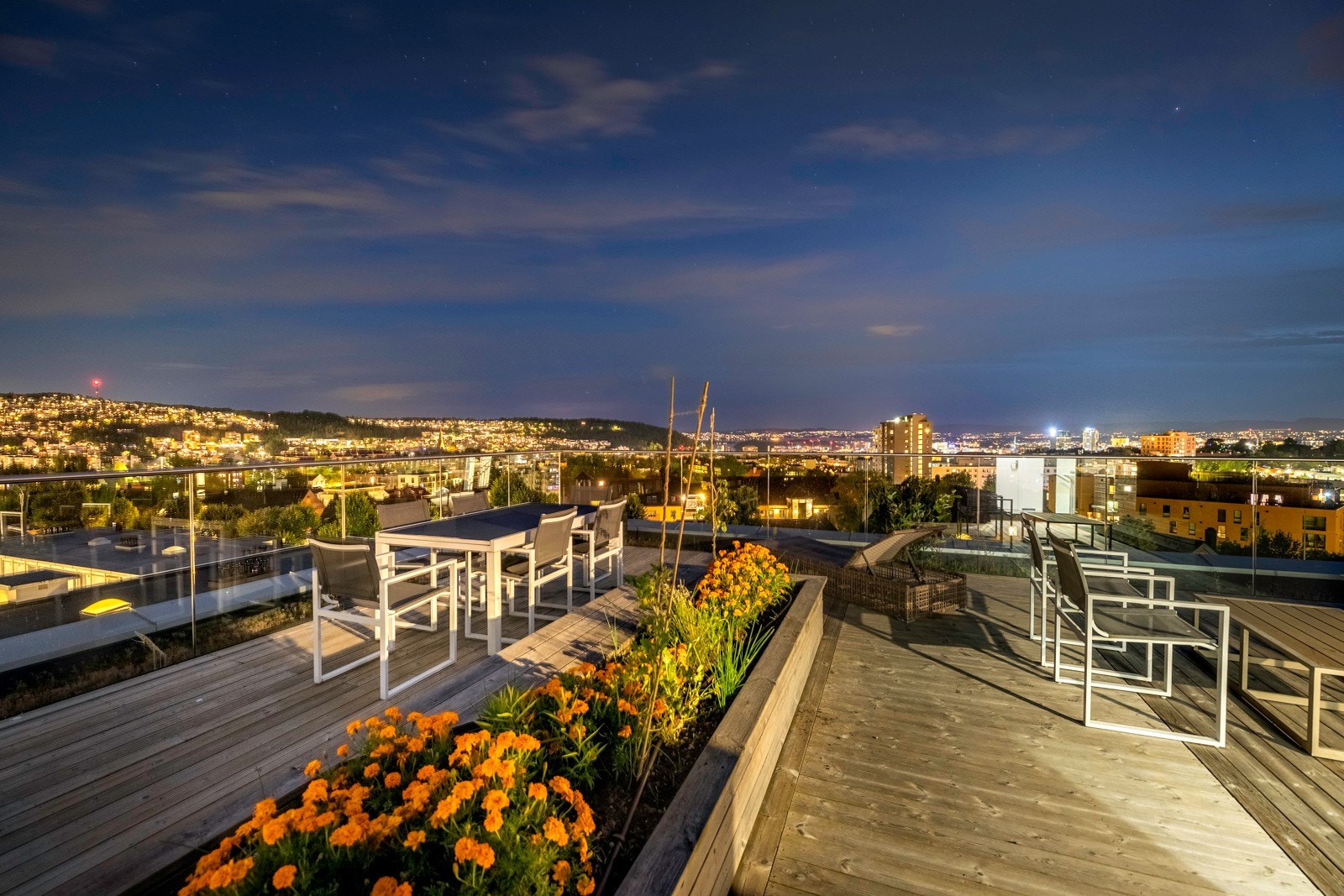 Takterrassen har beplantning, pergola, sittebenker og spisebord. Galleribilde
