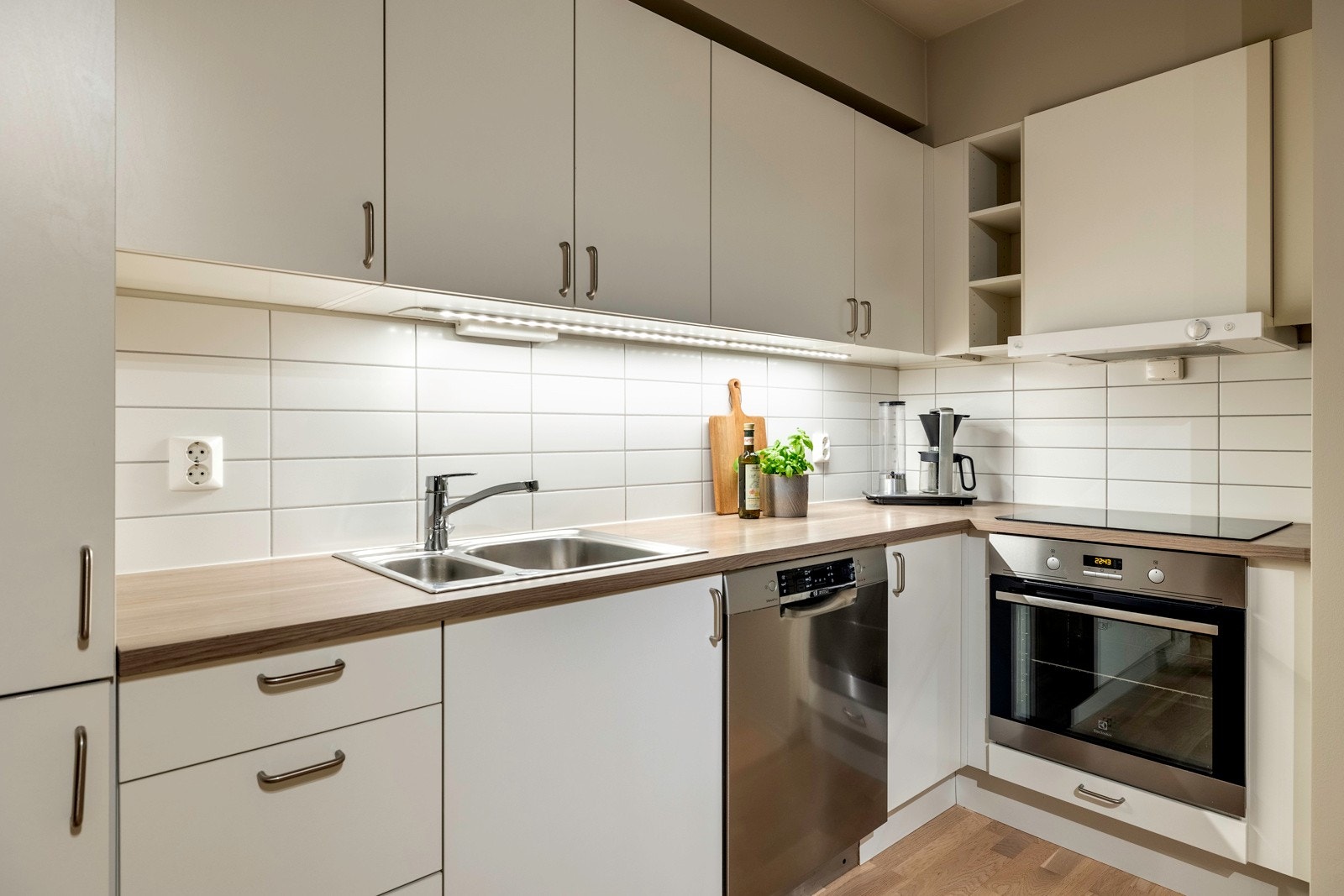 Det er montert belysning under overskapene ved vasken, og det er lagt fliser på veggen mellom overskap og kjøkkenbenk. Galleribilde