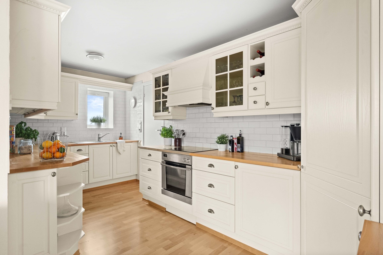 Strai kjøkkeninnredning fra 2002, med profilerte lyse fronter og benkeplate i tre, oppvaskkum og ettgreps blandebatteri. Galleribilde