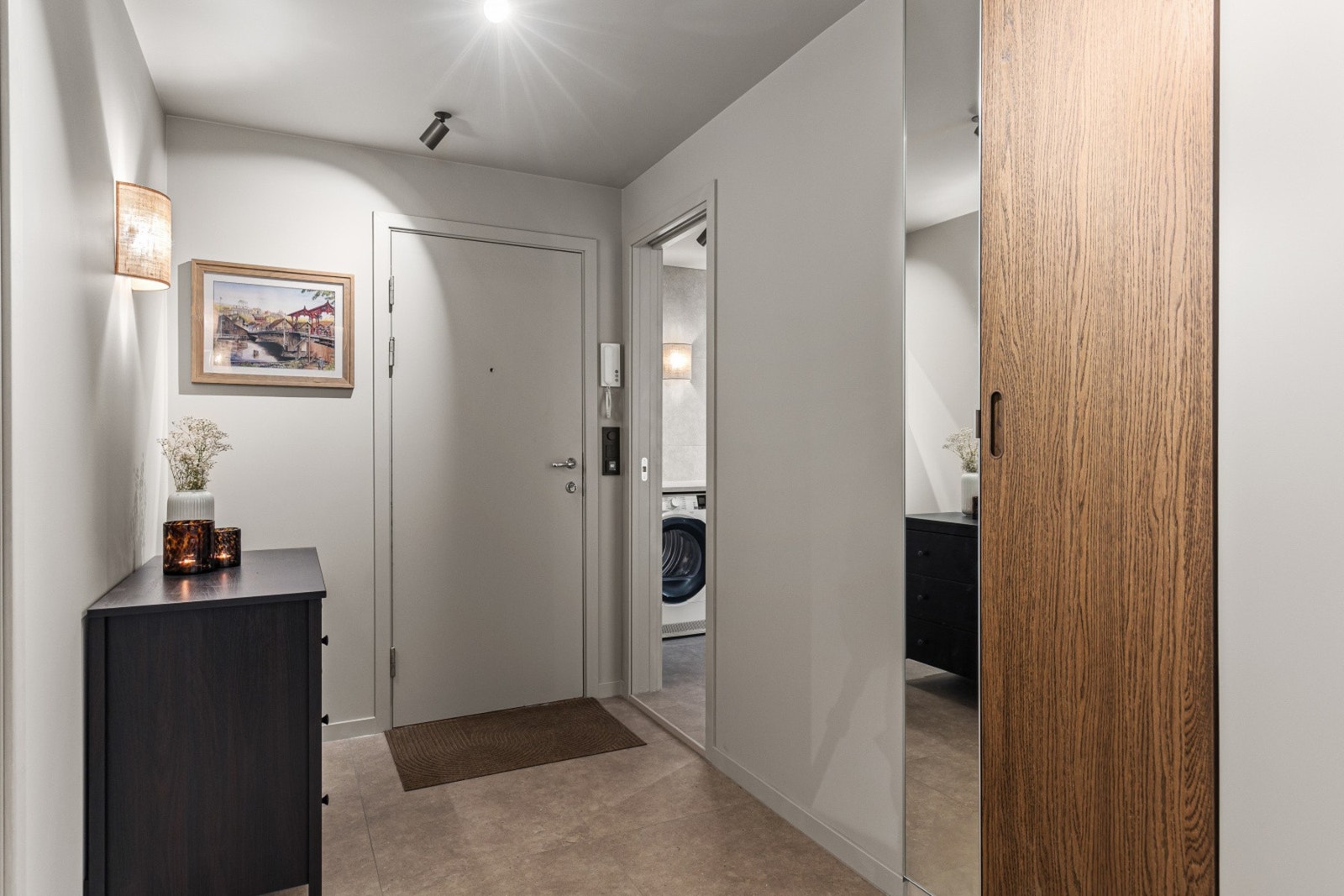 Inne blir du møtt av en flislagt entre på 5,5 kvm. med behagelig varme i gulvet. Nydelig plassbygd garderobeløsning med speilfront. 60x60 flis. Galleribilde