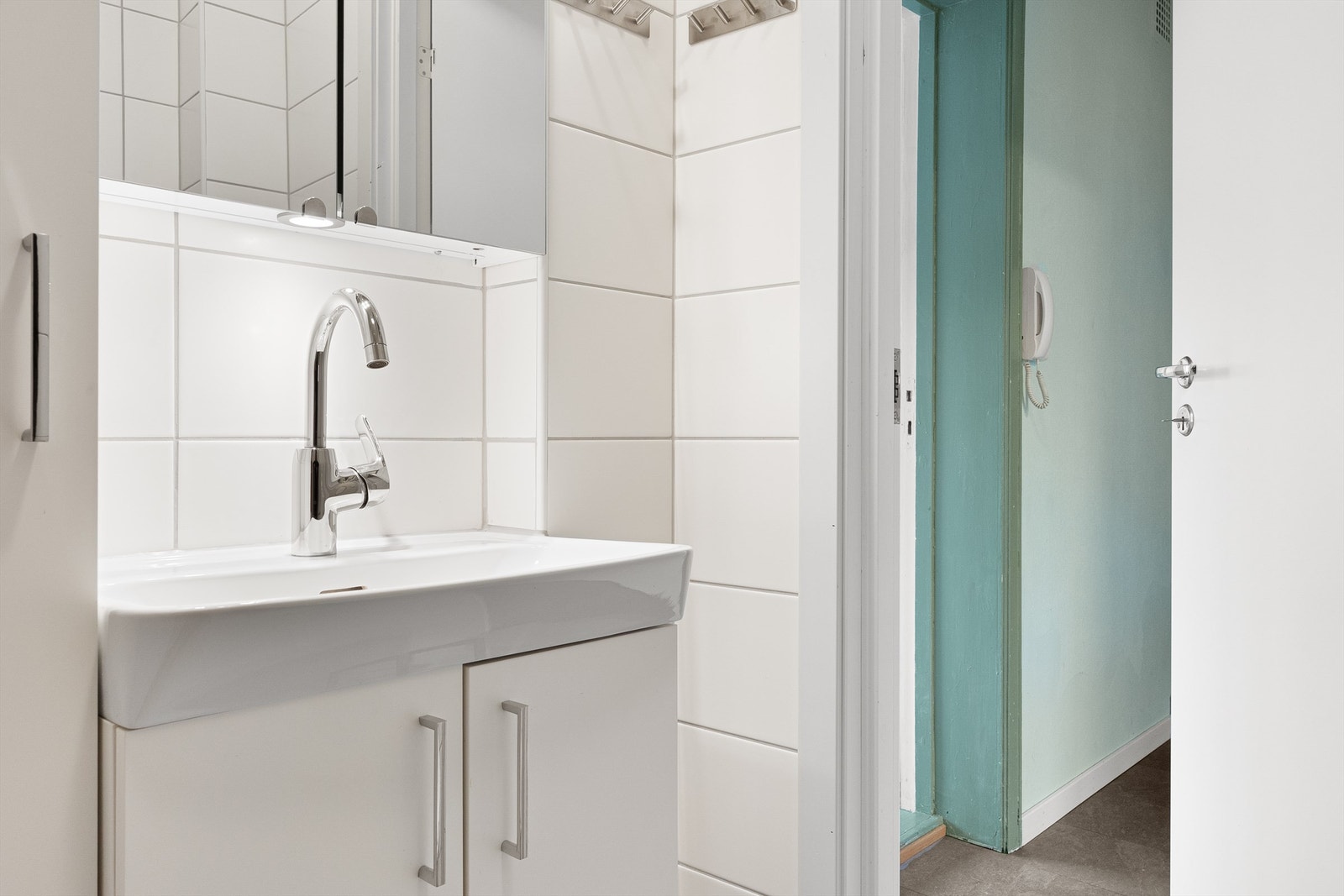 Pent flislagt baderom med fin baderomsinnredning og plass til vaskemaskin. Galleribilde